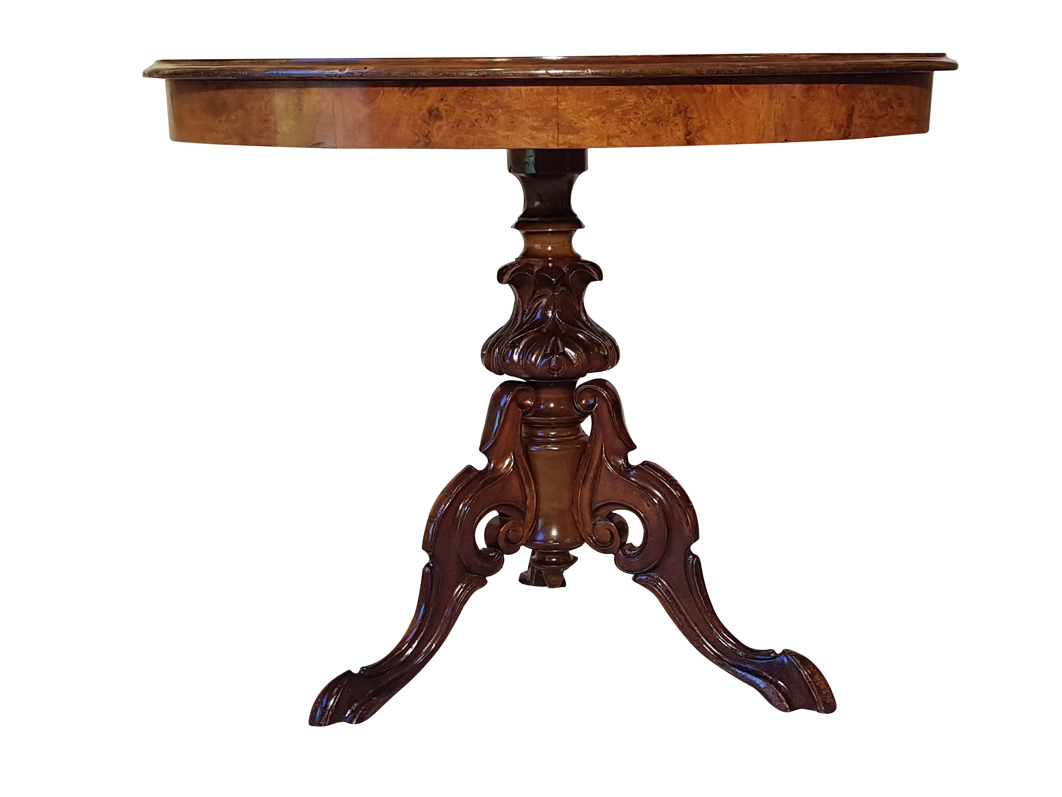 Antique side table made of a combination of a luxurious mahogany foot and beautifully grained walnut wood top. Restored 19th century piece with original patina and polished by hand with shellac. Features a wonderfully carved foot and an ellipsoid