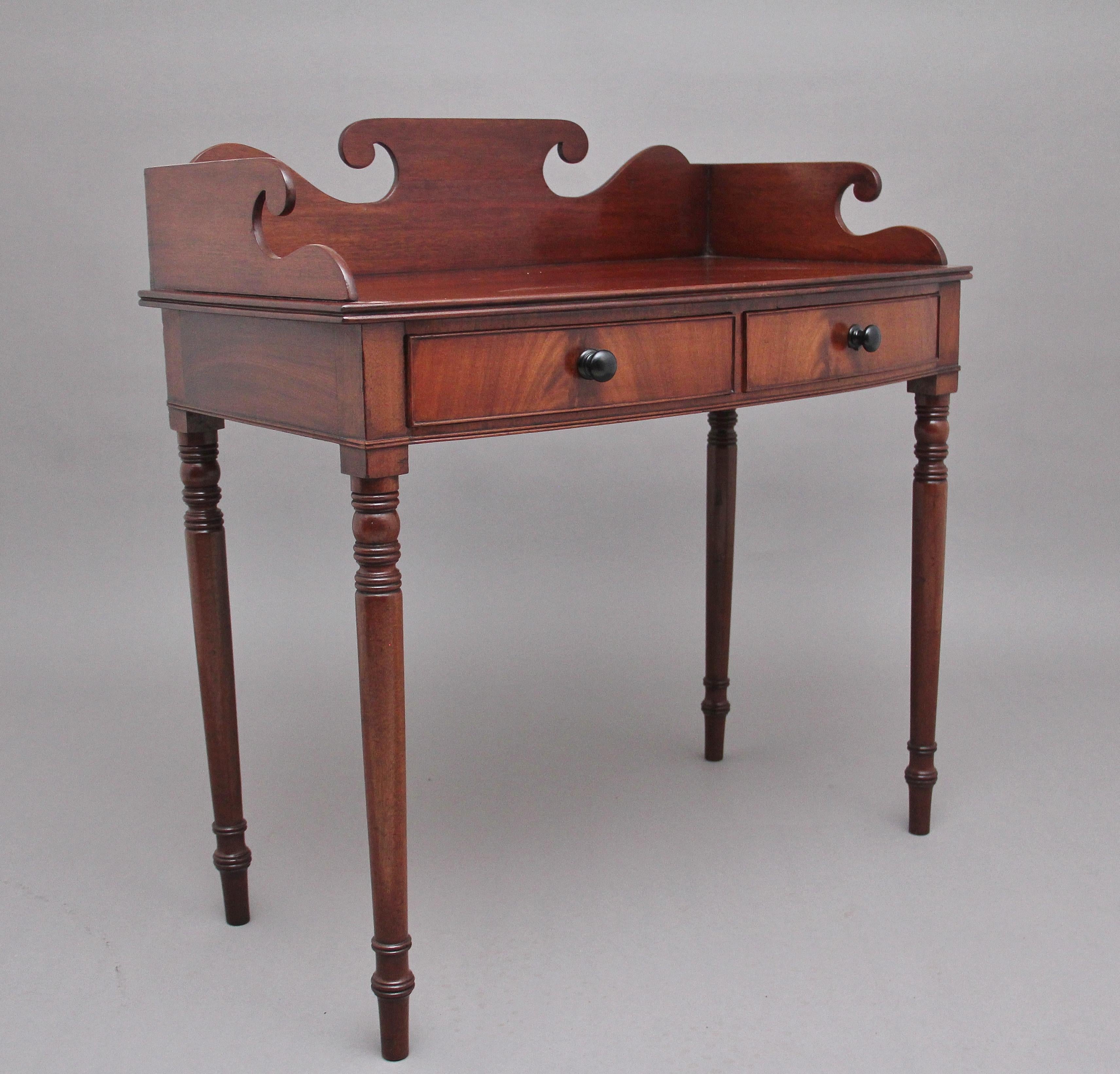 19th Century mahogany dressing / side table, having a decorative shaped frieze and nice figured top above two drawers with the original ebonised turned wooden knob handles, standing on four elegant turned legs. Circa 1840.