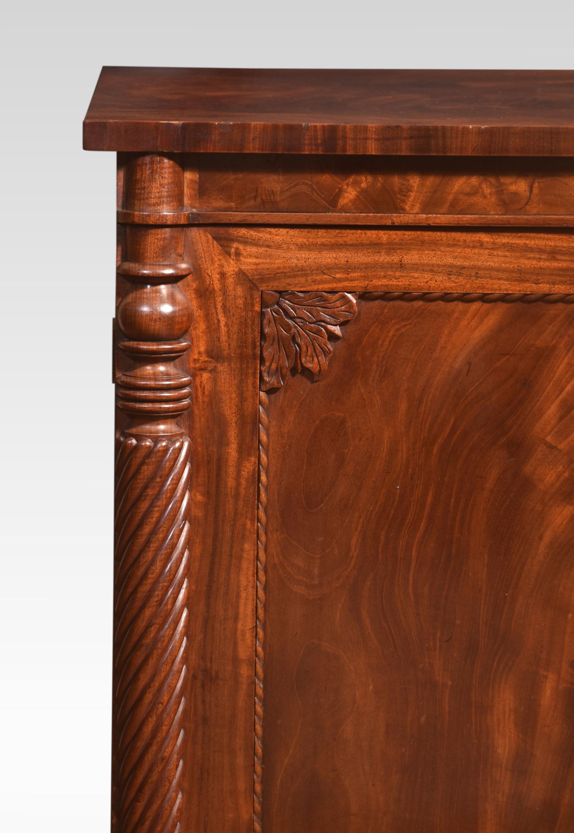 19th Century Mahogany sideboard, the well-figured rectangular top above-folded freeze supported on crisply carved spiral columns flanking two well-figured flame mahogany doors opening to reveal a fitted interior with bold brass ring handles. All