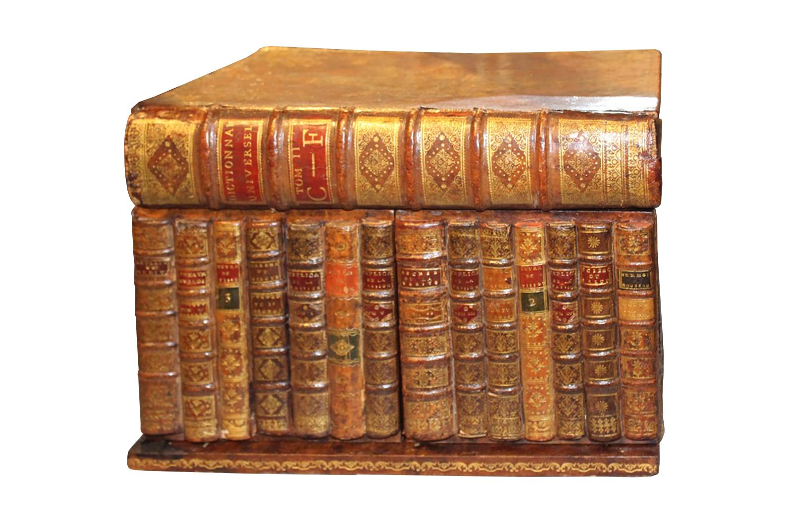 This 19th century tantalus is designed to look like a row of 14 leather bound books, covered by a large book stacked on top. Each book features different decorative detailing. This piece is made of mahogany, and includes an internal lift-out tray