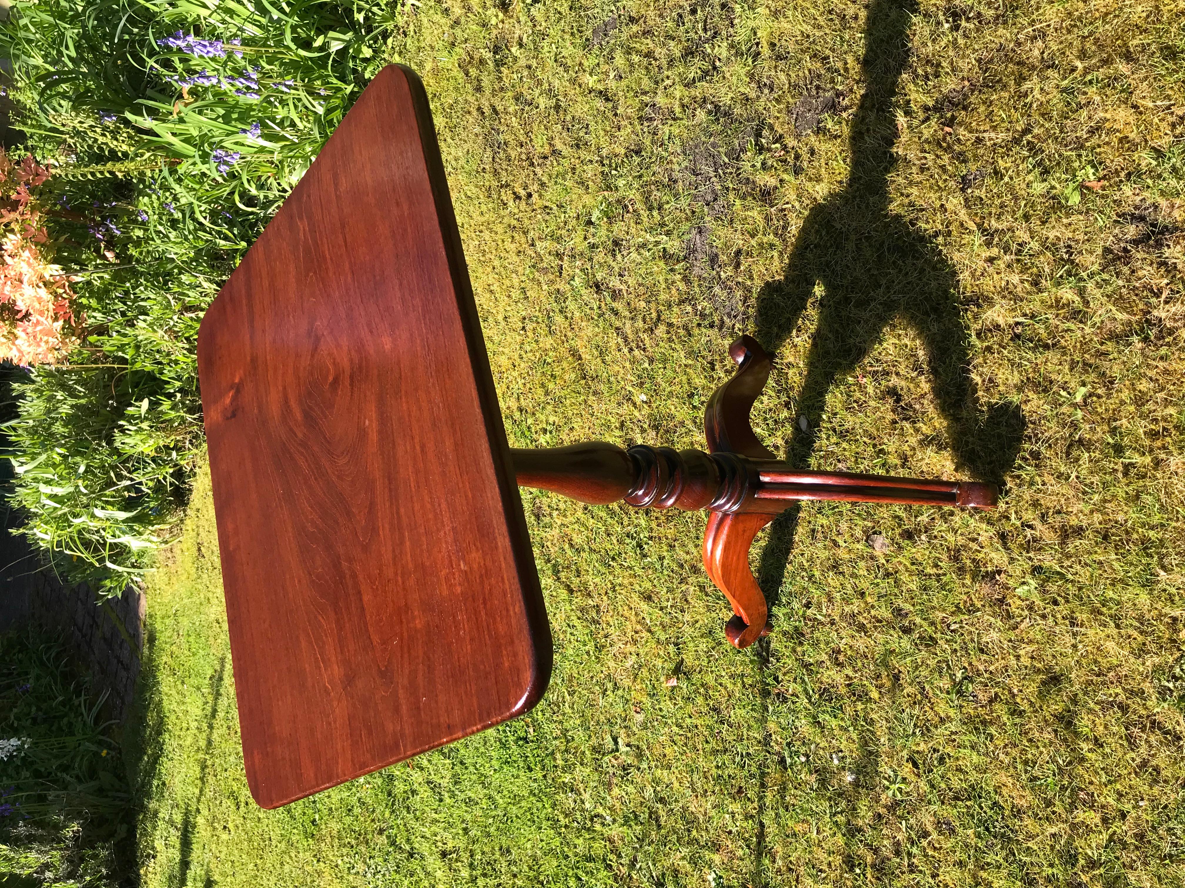 Beautifully figured solid mahogany rectangular tilt-top tripod wine table with turned baluster stem ending on three cabriole legs.