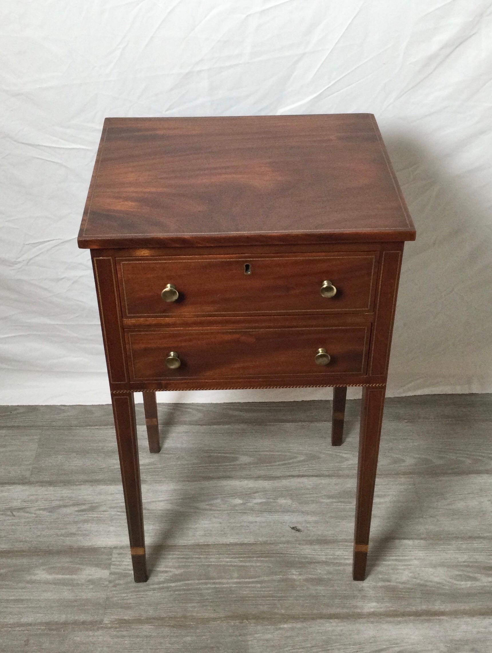 A well proportioned mahogany stand with tapered legs and nice string inlay along the sides with cuff feet detail.
