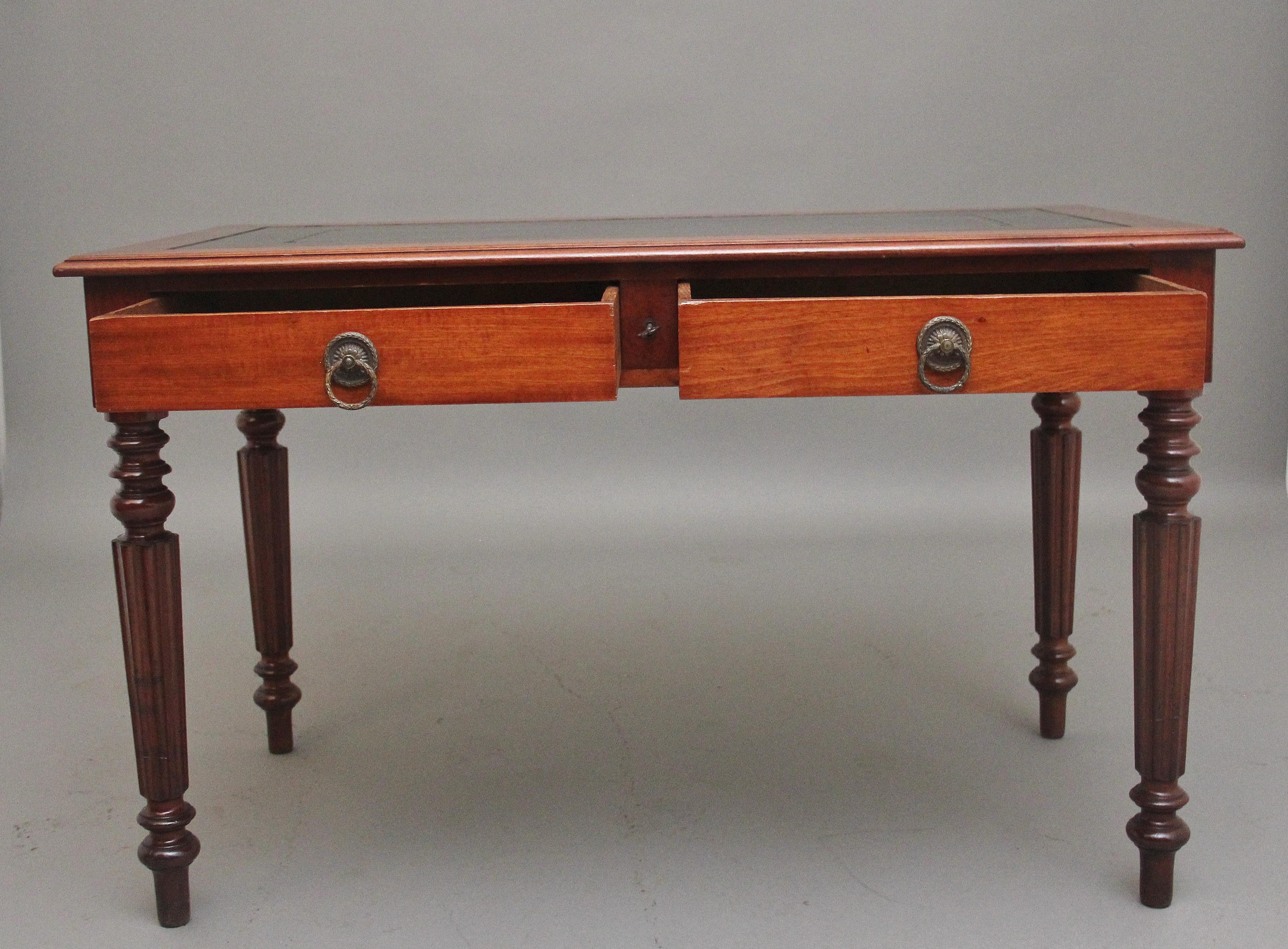 Table à écrire à deux tiroirs en acajou du 19ème siècle, le plateau à bord mouluré ayant une surface d'écriture en cuir noir avec des outils dorés et aveugles, deux tiroirs doublés en chêne en dessous avec des poignées en laiton gravées, supportés