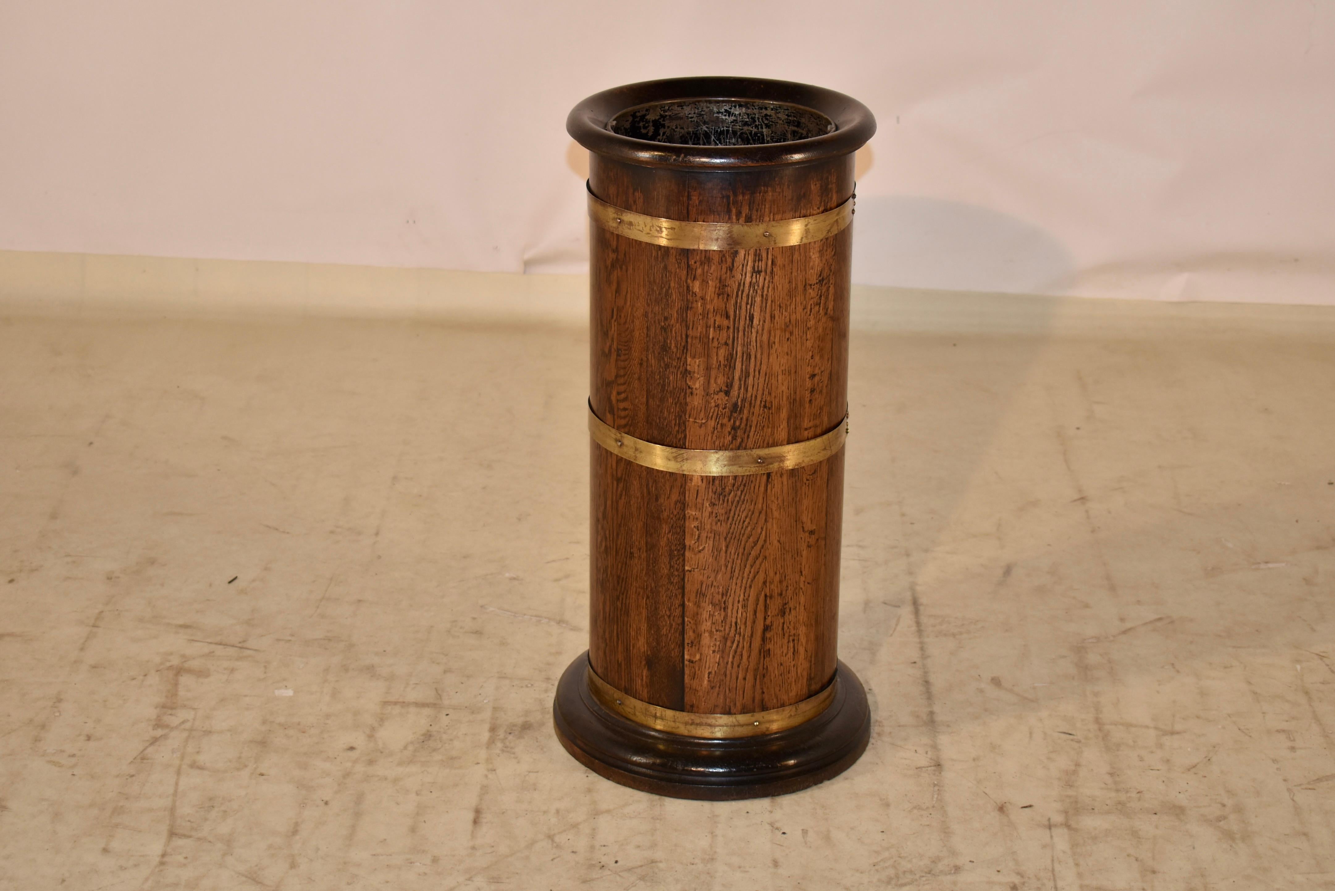 Wonderful 19th century mahogany circular umbrella stand with original metal insert and banded in brass on the sides. The base is turned and has layered bevelled edges for added interest.  This is a very unusual umbrella or stick stand due to its