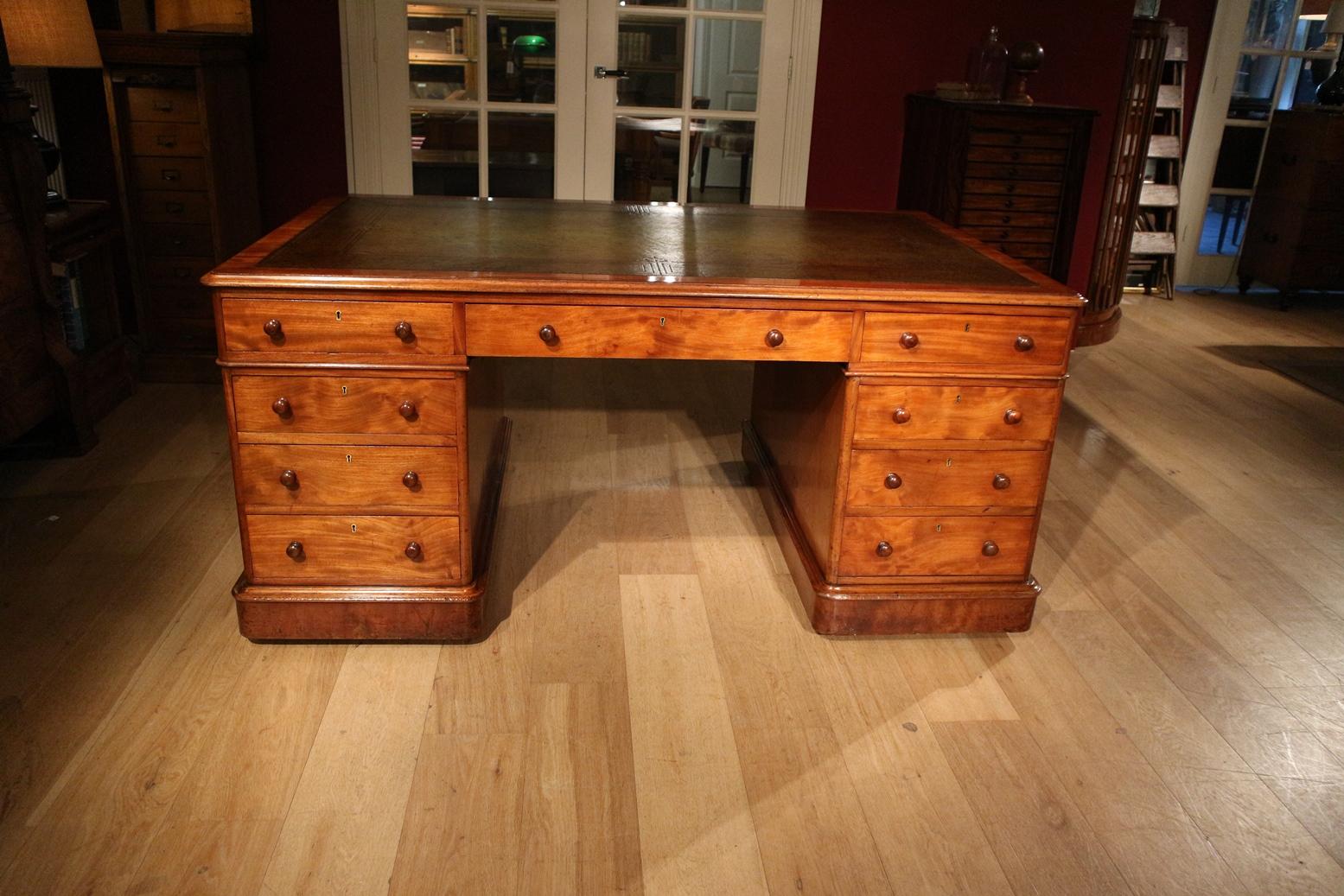 Beautiful antique mahogany partner desk in perfect condition. Desk of special quality. Desk has 9 drawers on both sides. This not only looks beautiful but is also functional. The desk has a very warm light color and green leather that is richly