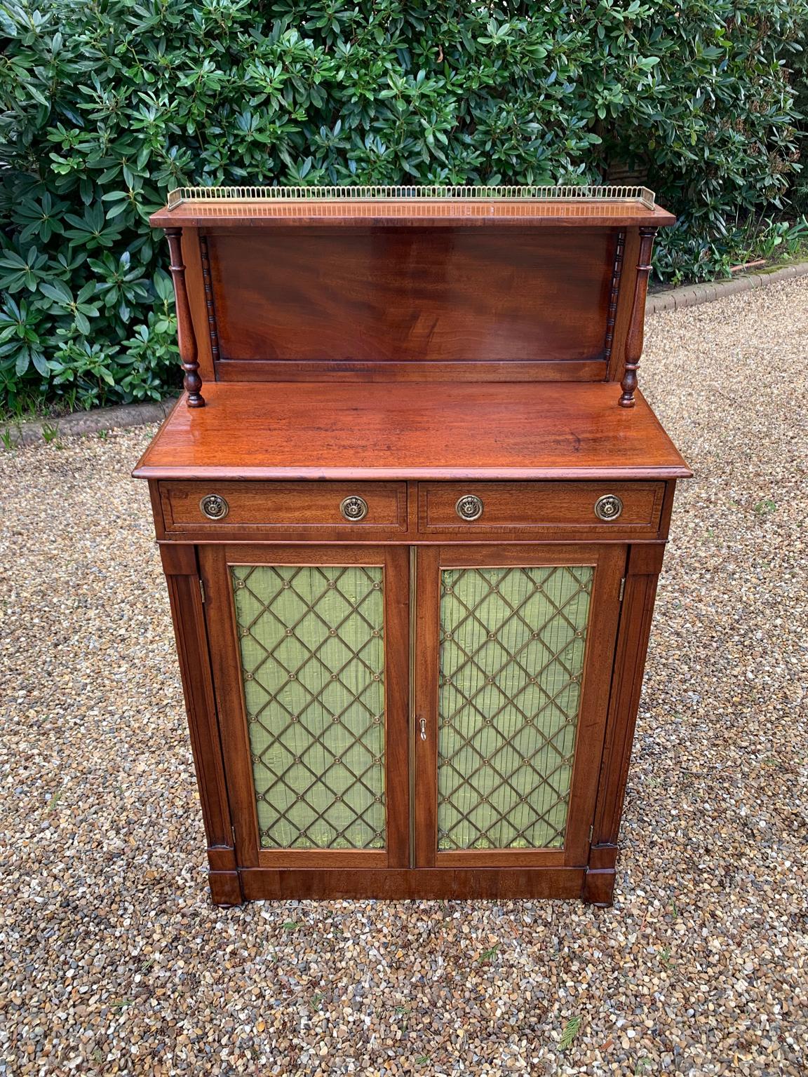 19th Century Mahogany Victorian Chiffonier, with two drawers with brass ring handles. Supported by baluster turned columns with a brass gallery on top, above moulded freize and brass grille pleated doors, supported on plinth base.

Circa: