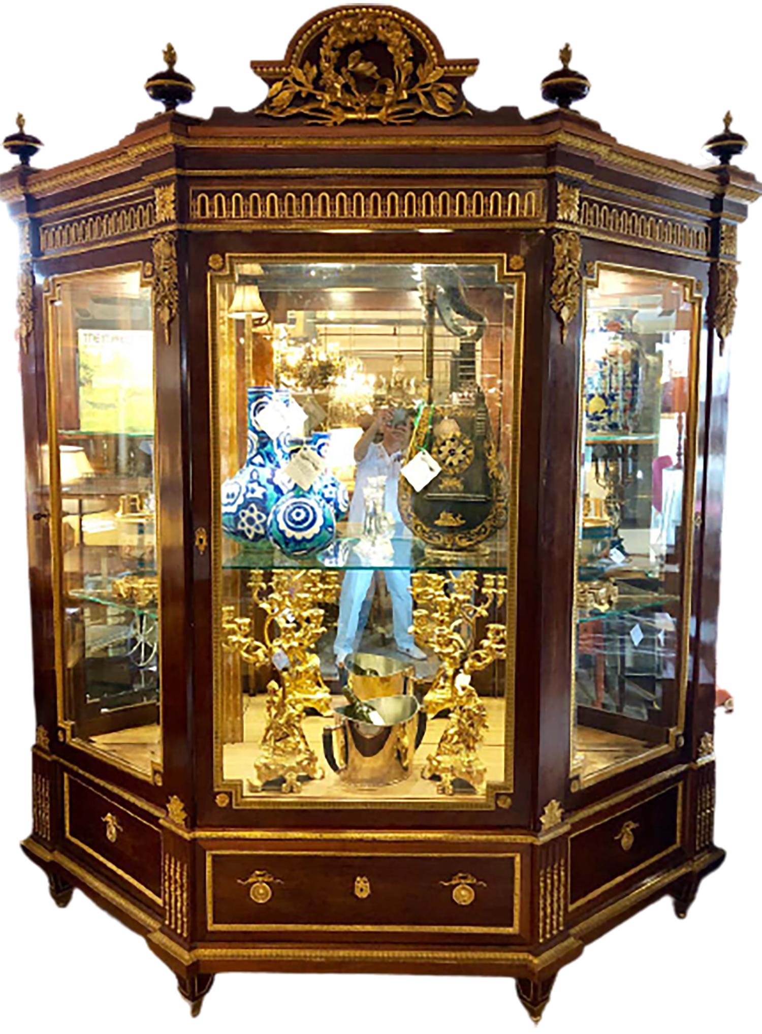 19th century link quality mahogany vitrine cabinet having spectacular bronze mounts stamped Grohe. This Important and Impressive Louis XVI style cabinet is larger than life as it can sit center stage in any room or office. The full beveled glass