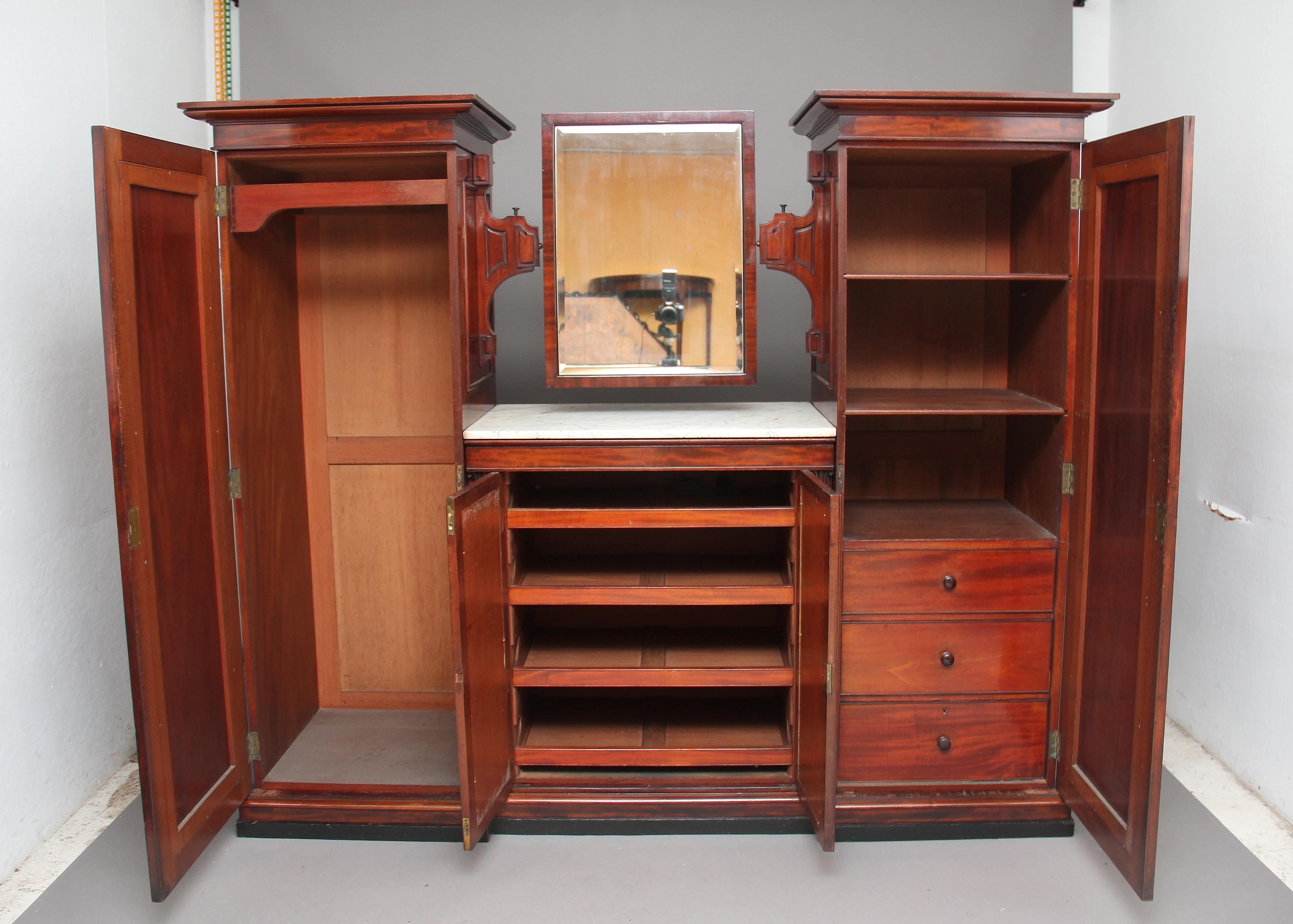 19th century mahogany wardrobe of nice proportions with a door at either end, opening to reveal on the left side full hanging space and on the right three drawers and three shelves, between these are a pair of doors with four sliding trays with a