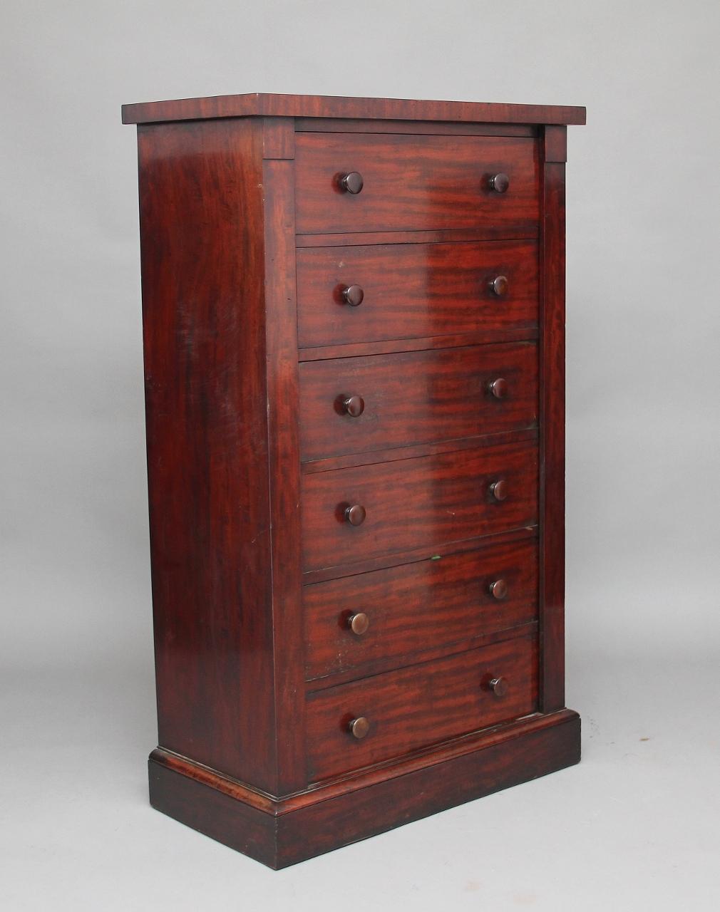 19th century mahogany Wellington chest attributed to Gillows, a lovely rich mahogany color with six mahogany lined drawers with original wooden knobs, the top drawer front drops down to reveal partitions, the other drawers have hinged lids on the