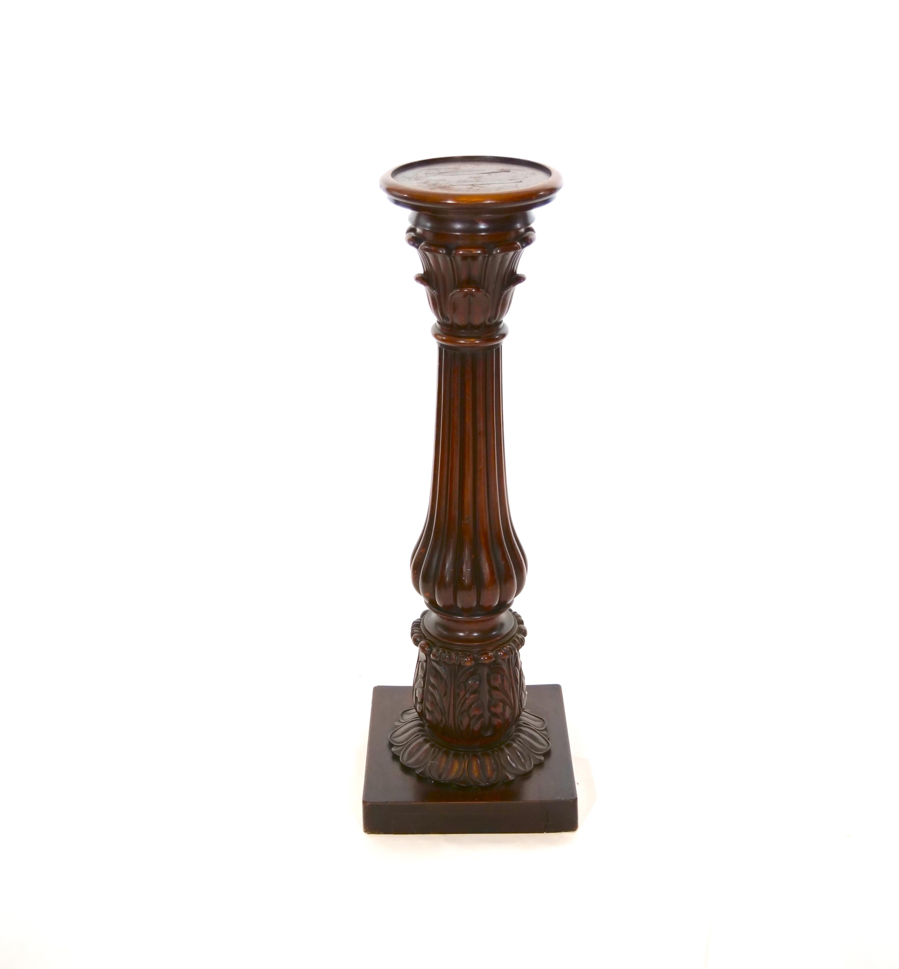 Early 19th century mahogany wood Regency style pedestal stand / table. The pedestal features hand carved design details resting on a squared based. The pedestal table is in good antique condition. Appropriate wear consistent with age/ use. It