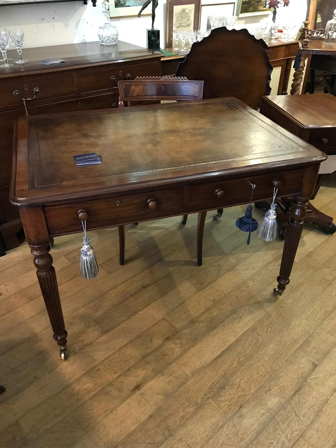 A high quality 19th century mahogany writing table with rounded corners front and back with two solid mahogany drawers and turned bun handles. With a newly re-leathered writing surface, on reeded legs and original castors to base.
circa