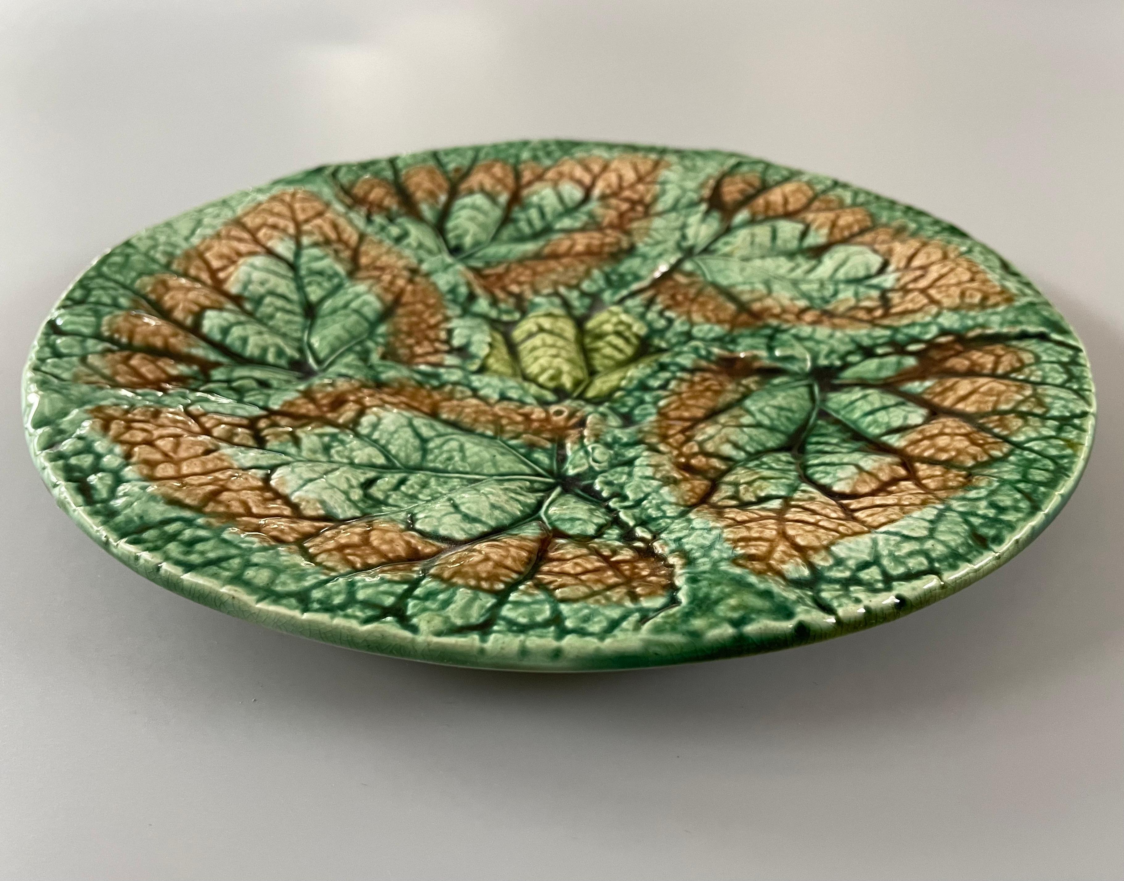 Ein Majolika-Teller aus glasierter Keramik des 19. Jahrhunderts mit Begonienblättern von Griffen Smith & Hill. Ein schön strukturierter etruskischer Majolikateller mit sich überlappenden grünen und braunen Blättern. Grüne und goldene Glasur auf der