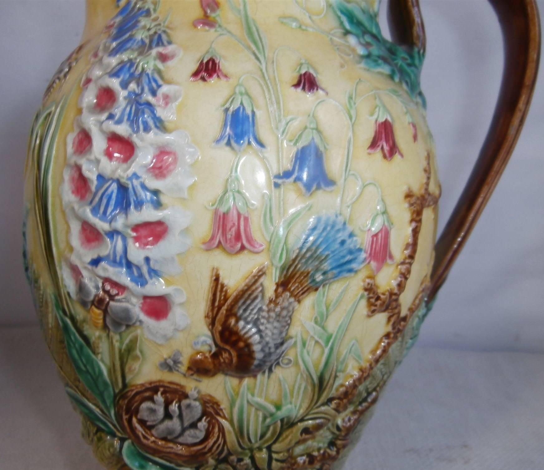 Rare Majolica pitcher decorated with differents patterns on the two sides, one side with bird, lily of the valley, morning glory and others greens leaves, the other side with floxgloves, butterflies, ferns, bird on nest circa 1870 (Manufacture of