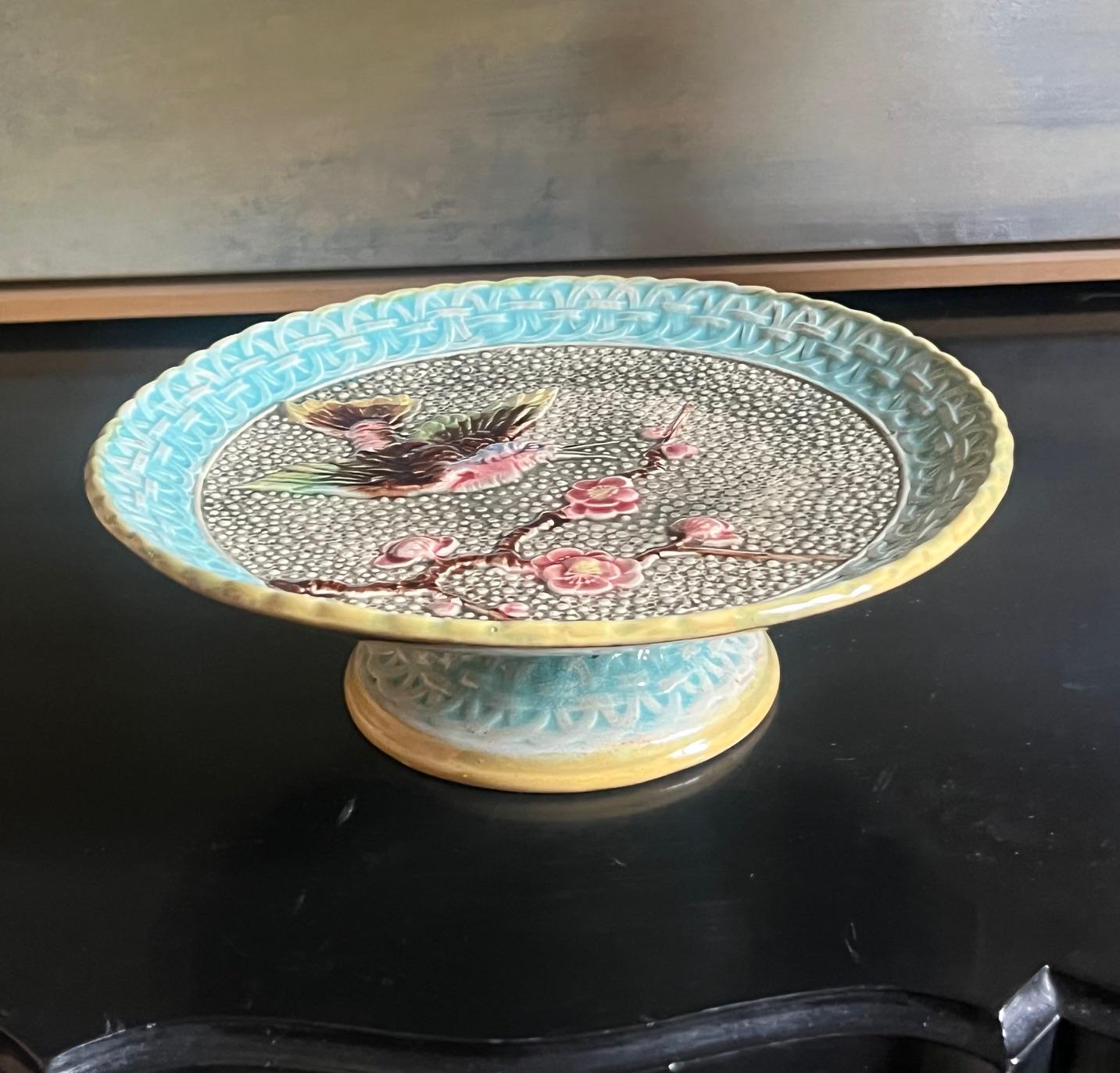 Handbemalter Majolika-Kuchenständer aus dem 19. Jahrhundert. Das Oberteil ist mit einem Vogel und Blumen in einem blauen Gittermuster mit gelber Umrandung versehen.