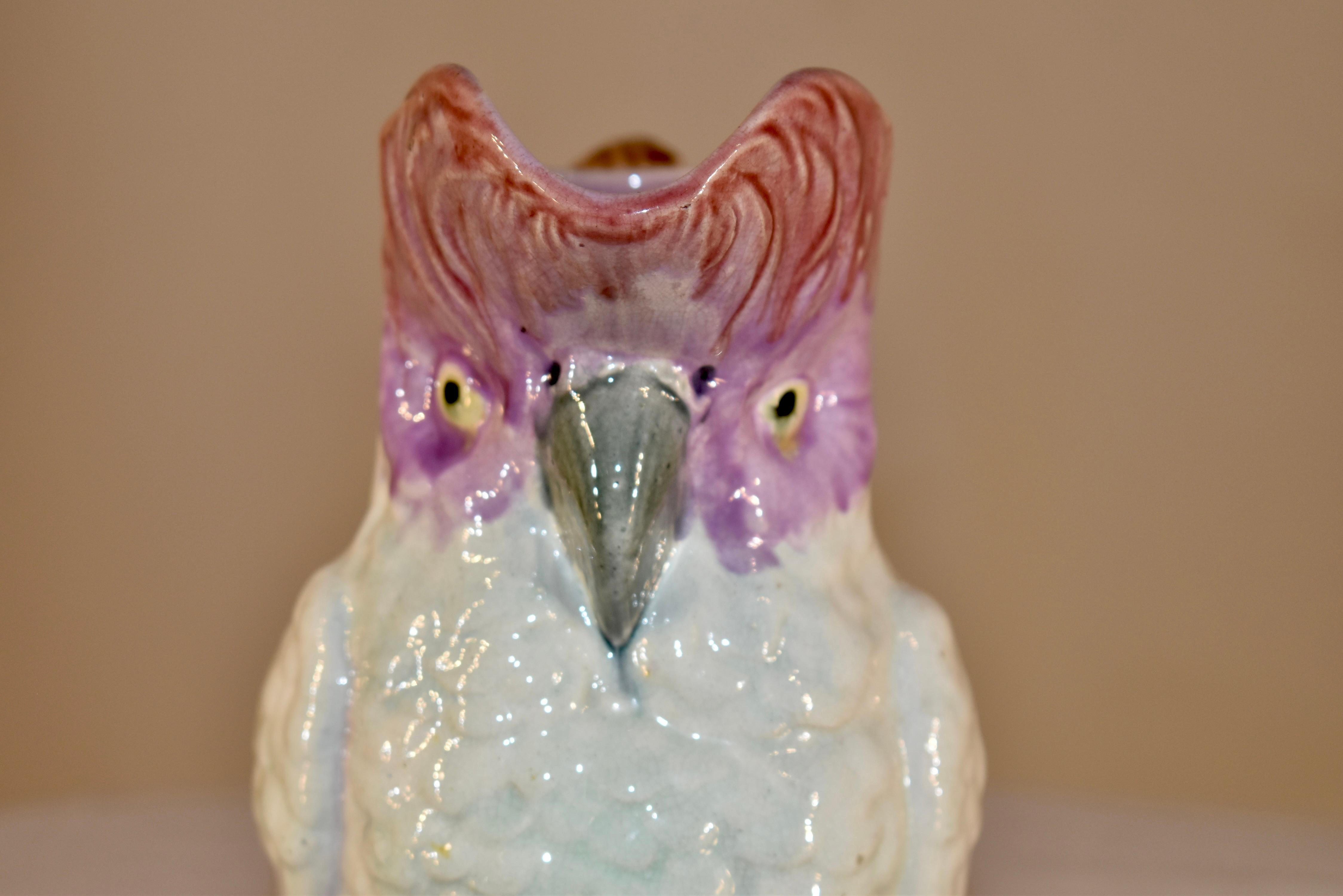 19th Century ceramic majolica pitcher in the form of a cockatoo. The colors are lovely and vibrant. The handle of the pitcher is in the form of bamboo, which is a really interesting detail. Lovely and whimsical.