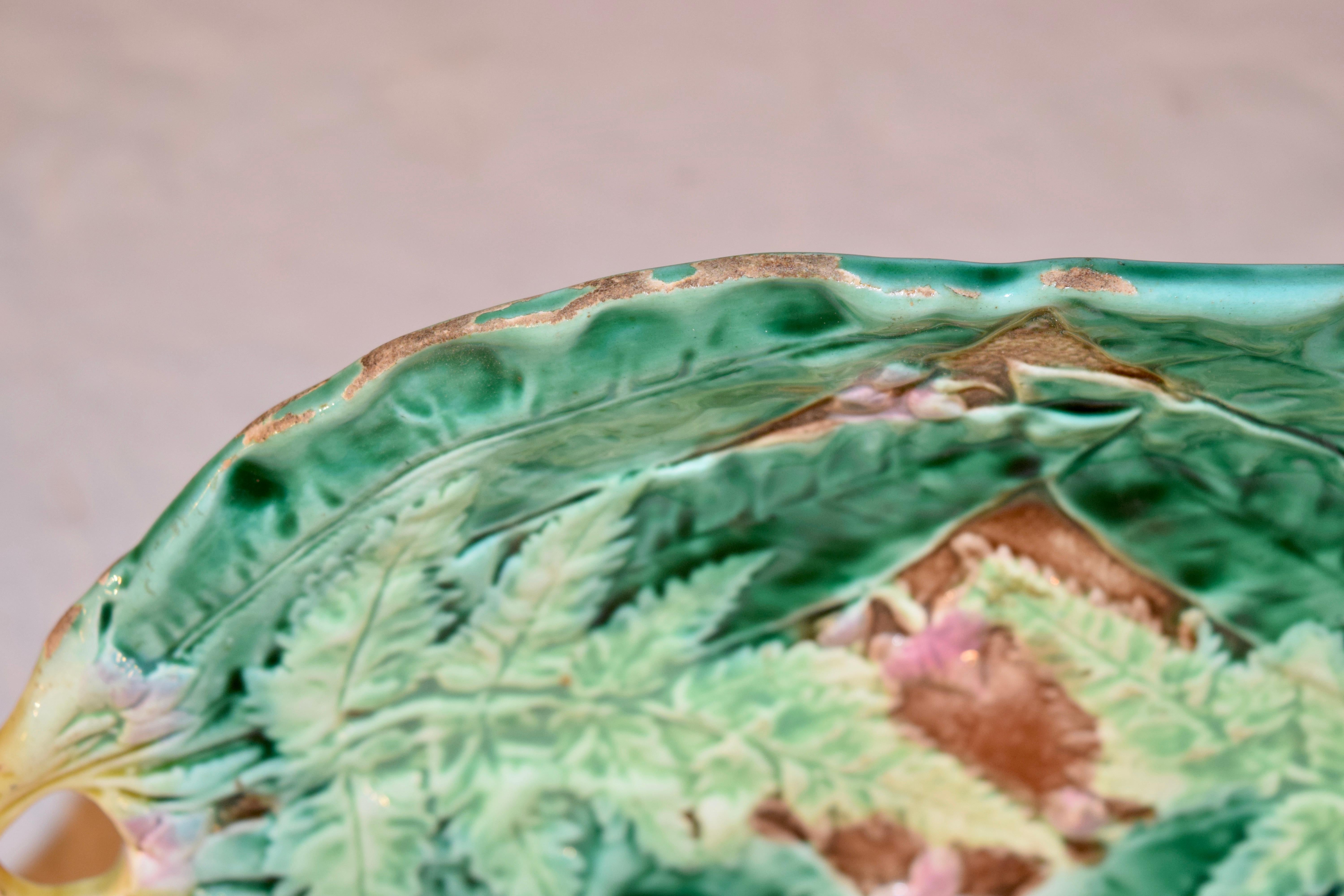 19th century Majolica tray with leaf and fern decoration. The dish is brightly colored in shades of brown, green, yellow and pink.