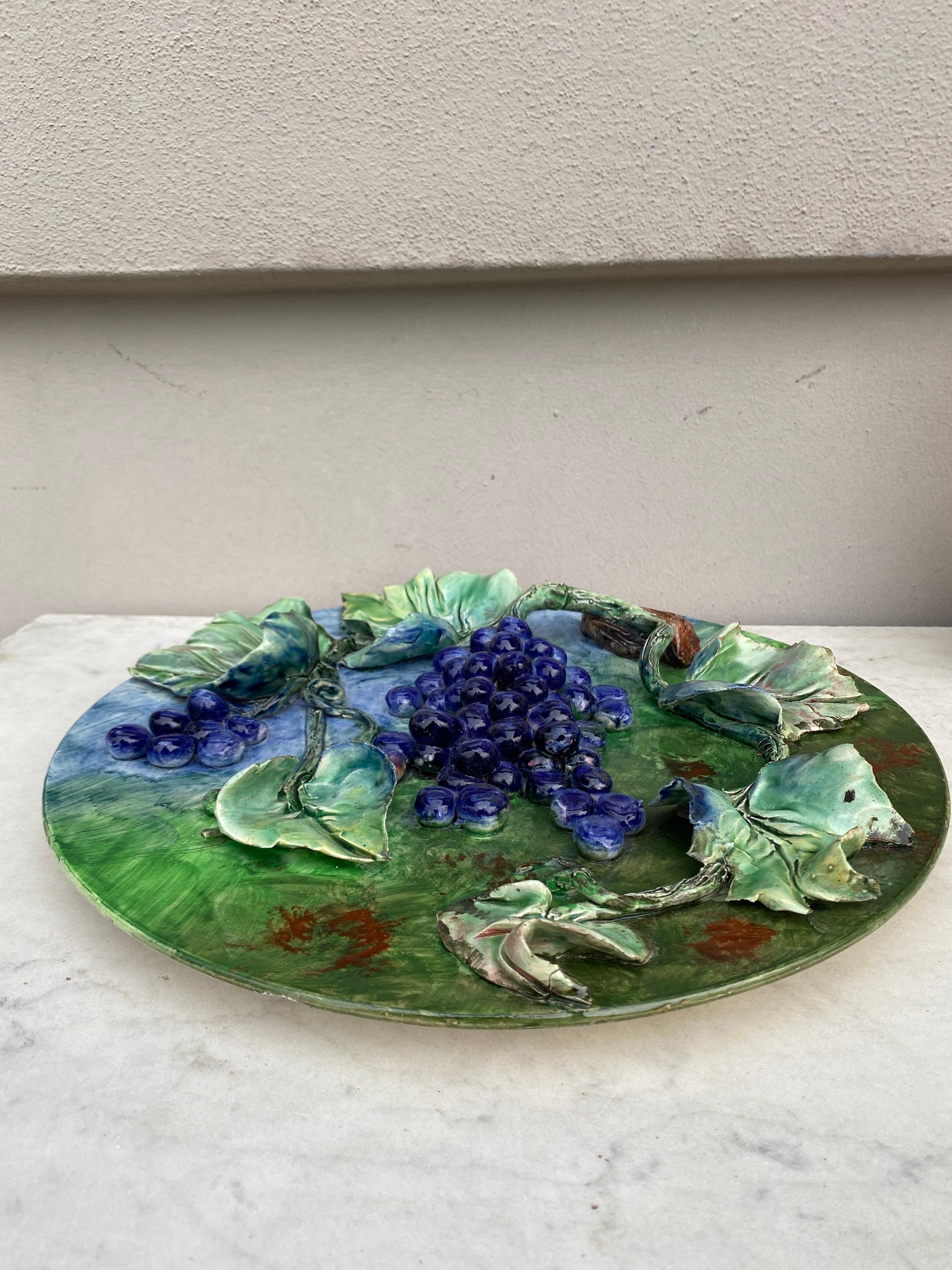 Colorful 19th century French Majolica grapes wall platter signed Longchamp terre de fer. The fruits are in high relief with the leaves and branches.
The manufacture of Longchamp produced this fruits platters with various fruits in four different