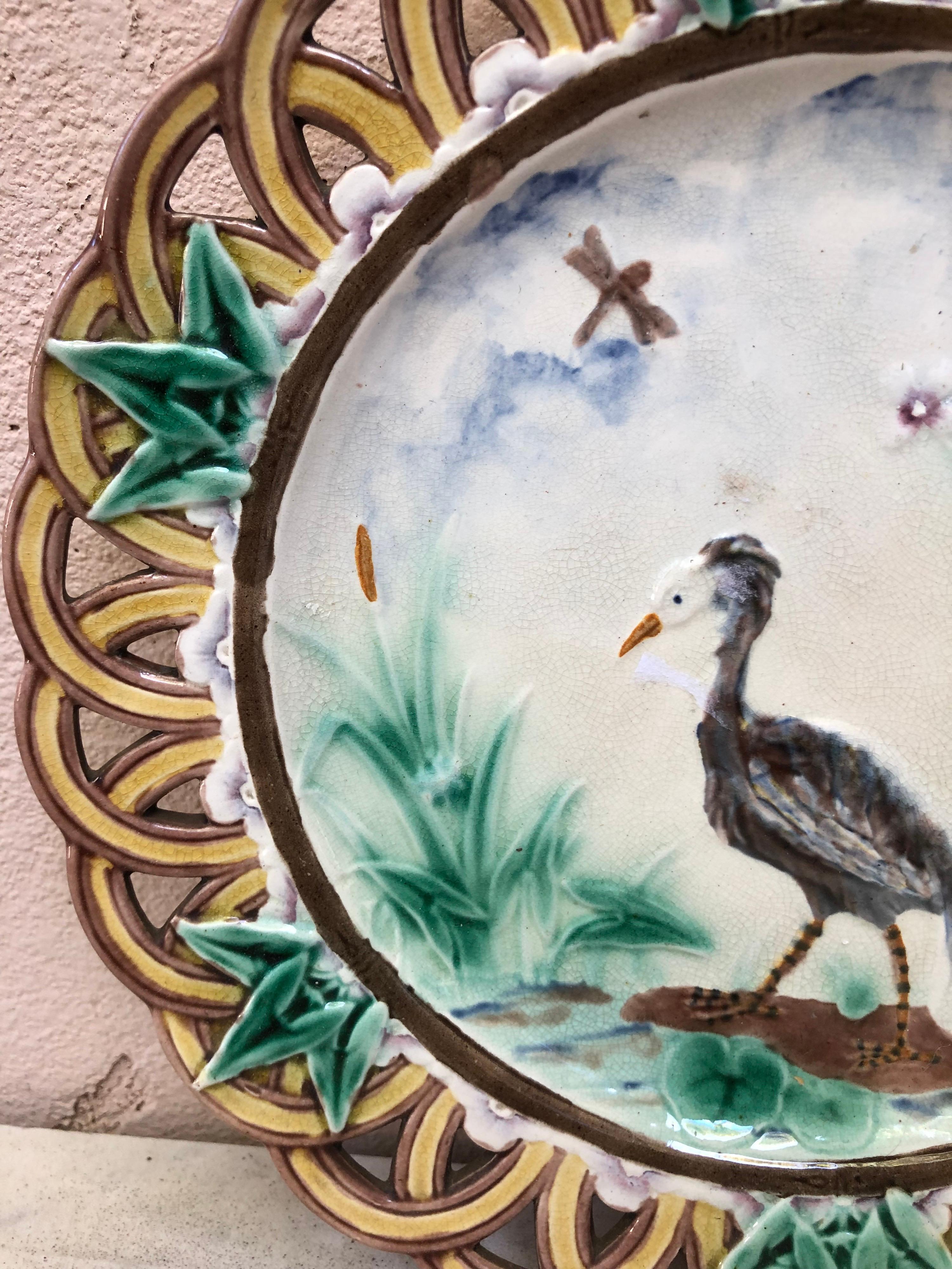 A fine Victorian Majolica reticulated plate signed Wedgwood.
The border is decorated with ivy leaves, the centre is a landscape with a heron near a pond.