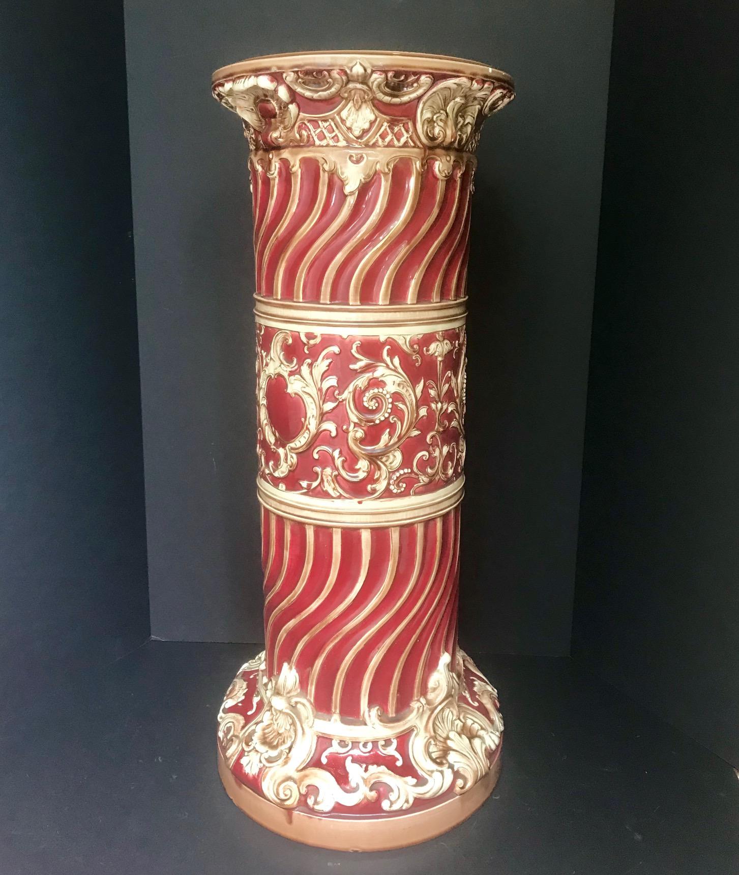 This large Victorian majolica pedestal has classic rocaille decorations. The vibrant and strong polychrome burgundy color is enhanced by the superb glaze. The ivory colored rocaille are accented with gilt highlights. Inside the glazed base the