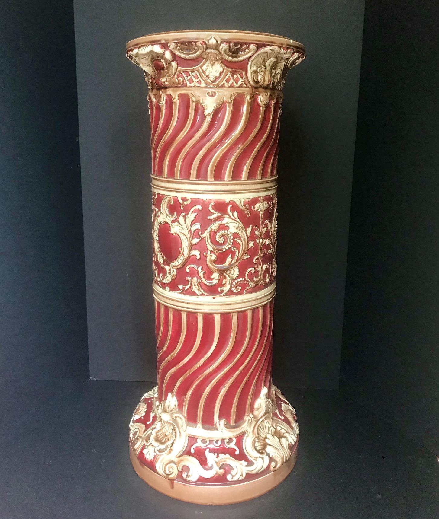This large Victorian Majolica pedestal has Classic rocaille decorations. The vibrant and strong polychrome burgundy color is enhanced by the superb glaze. The ivory colored rocaille are accented with gilt highlights. Inside the glazed base the