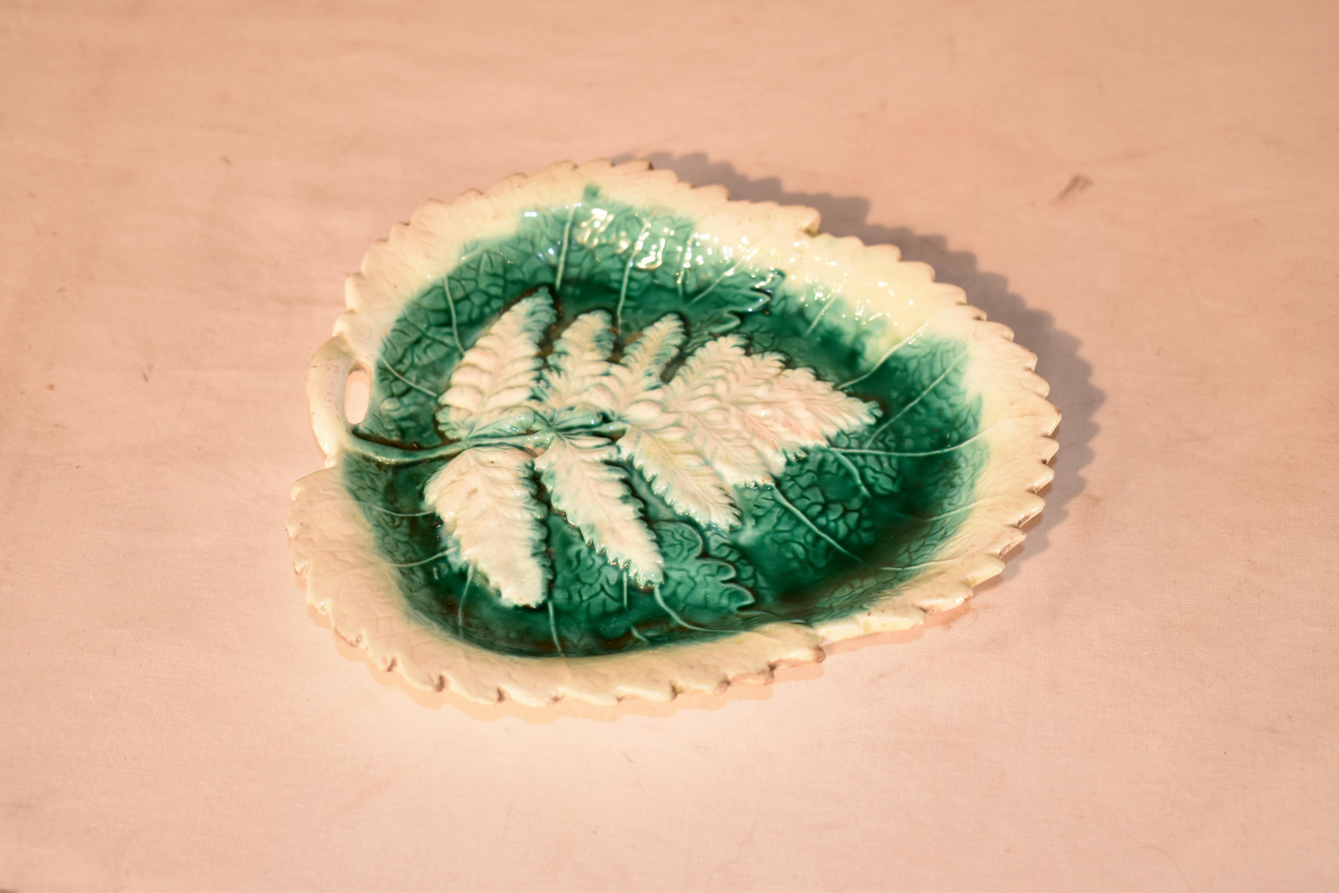 Plat à feuilles en majolique du 19e siècle, originaire d'Angleterre, avec un joli décor de fougères sur un lit de feuilles.  La feuille de fougère blanche contraste fortement avec le lit de feuilles vertes situé en dessous, et est entourée d'une