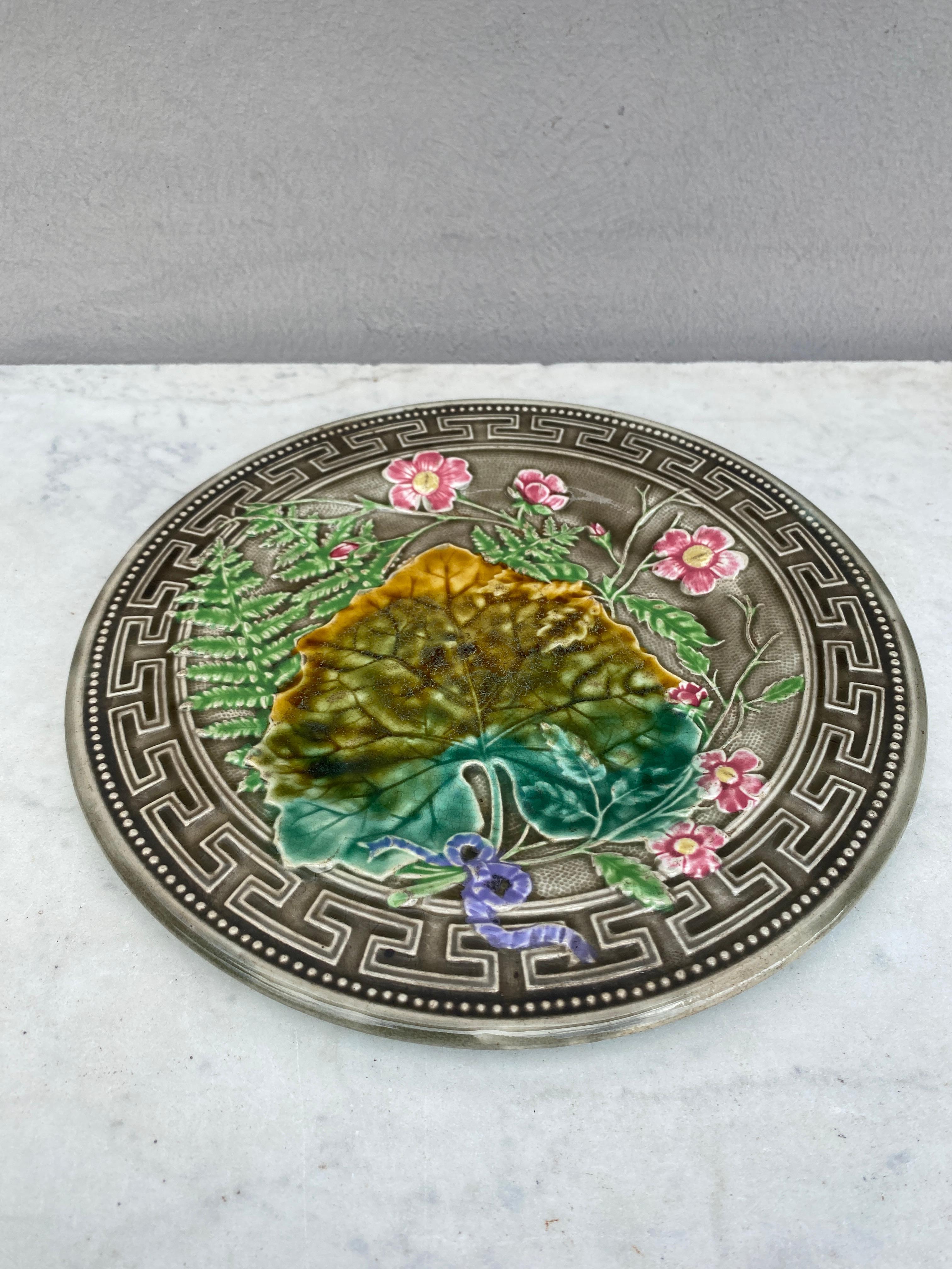 Majolica plate signed Choisy le roi, circa 1890.
Decorated with leaves, ferns, pink flowers and Greek border.