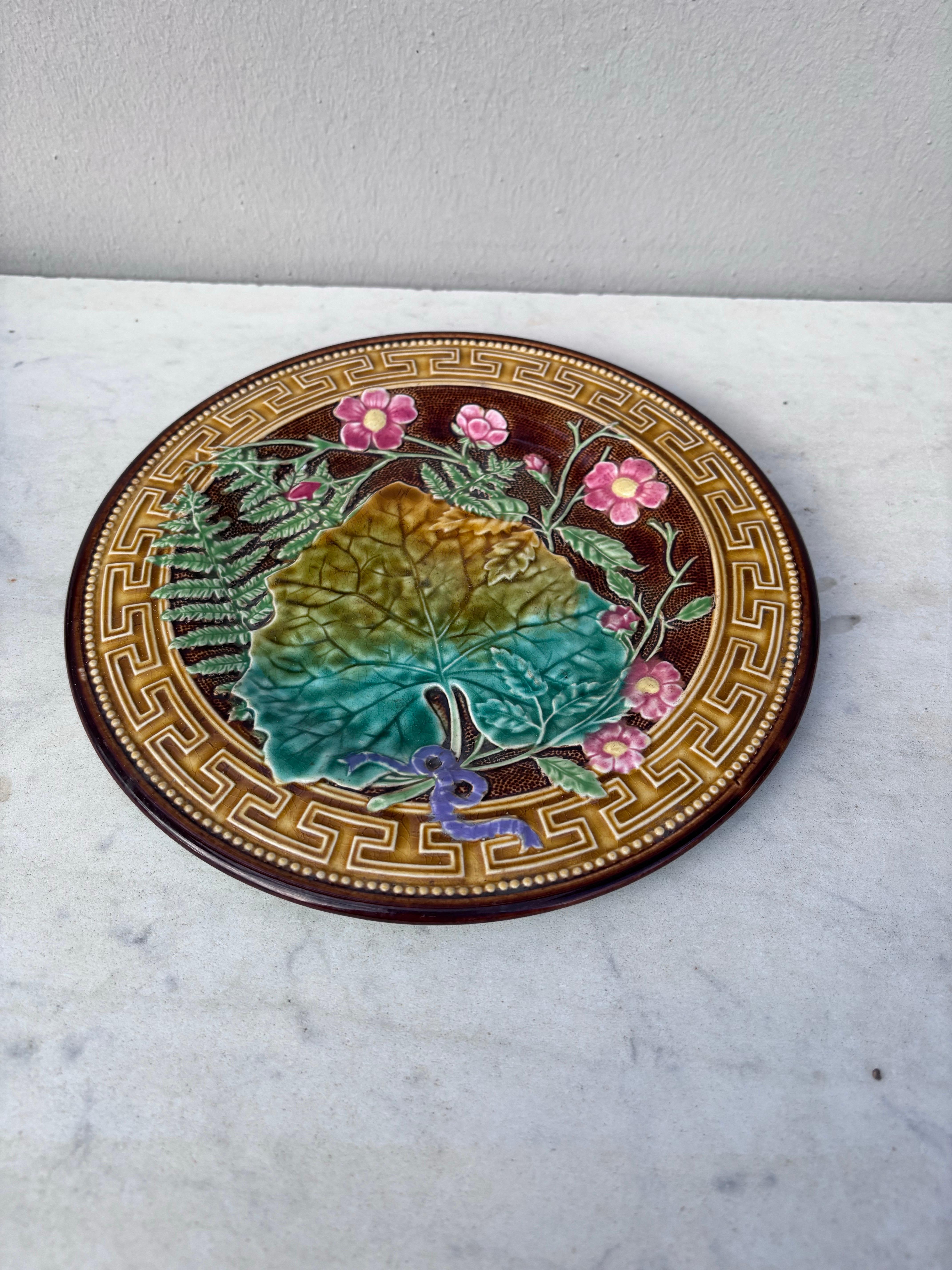 French Majolica plate signed Choisy le roi, circa 1890.
Decorated with leaves, ferns, pink flowers and Greek border.