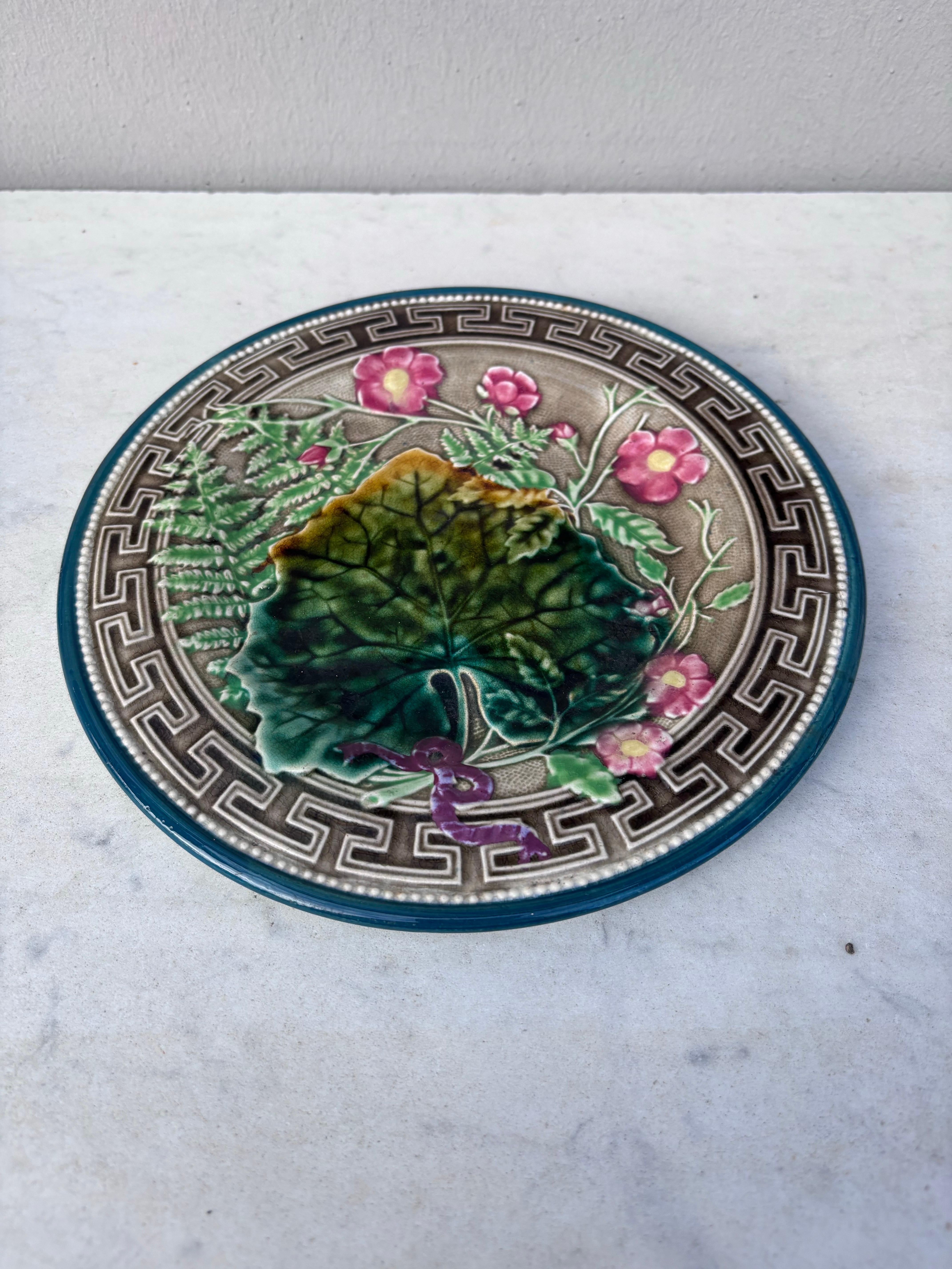 French Majolica plate signed Choisy le roi, circa 1890.
Decorated with leaves, ferns, pink flowers and Greek border.