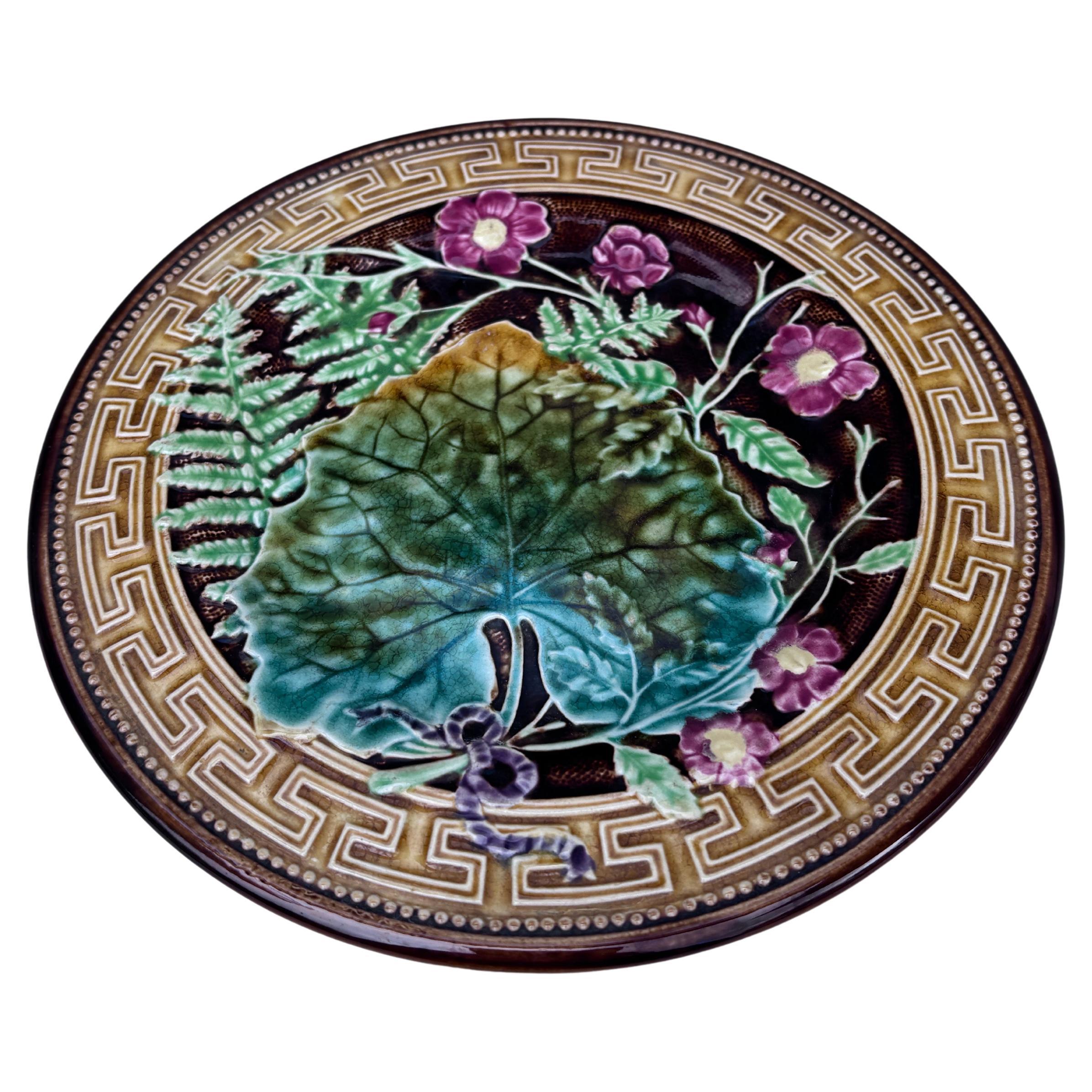 French Majolica plate signed Choisy le roi, circa 1890.
Decorated with leaves, ferns, pink flowers and Greek border.