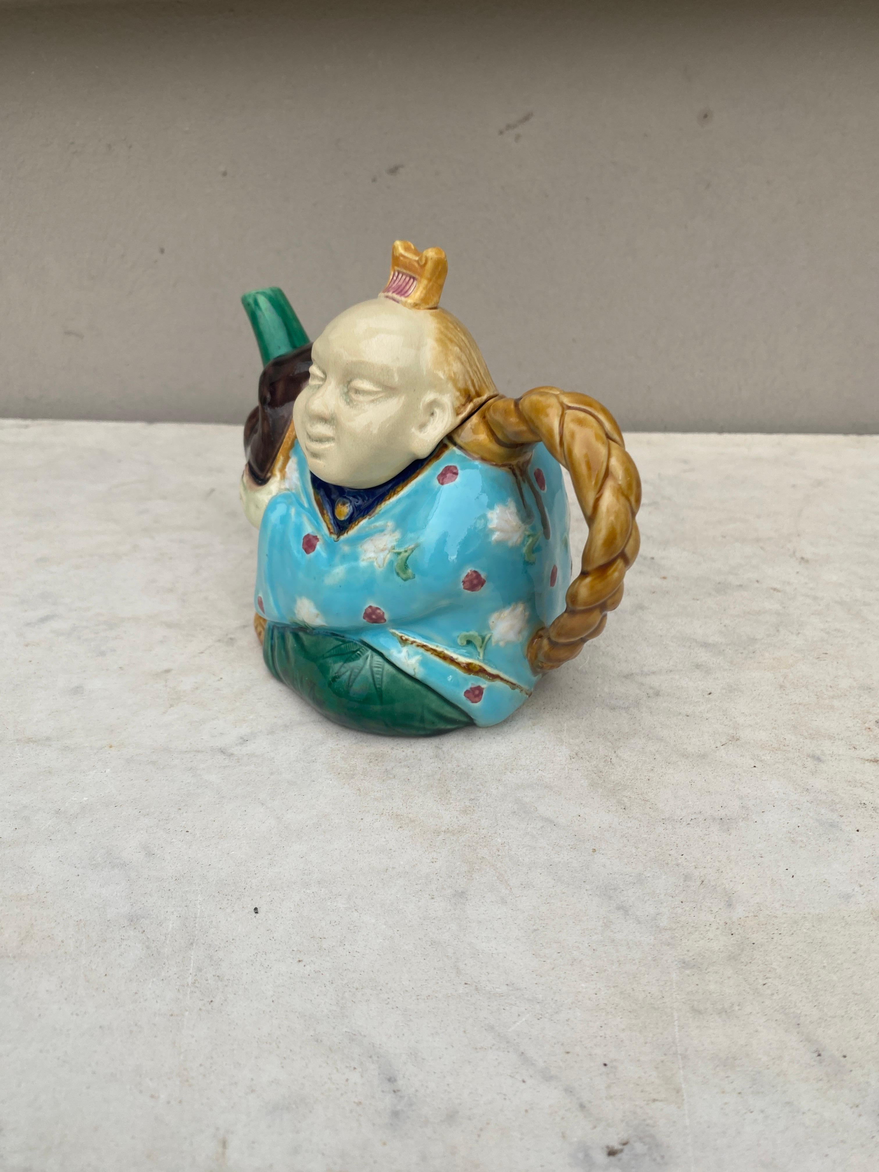 Majolica figural teapot signed Minton.
Modeled as a Chinaman , the tail formed as the Chinaman’s pigtail, his head forming the cover with his hair comb forming the finial.
Reference 