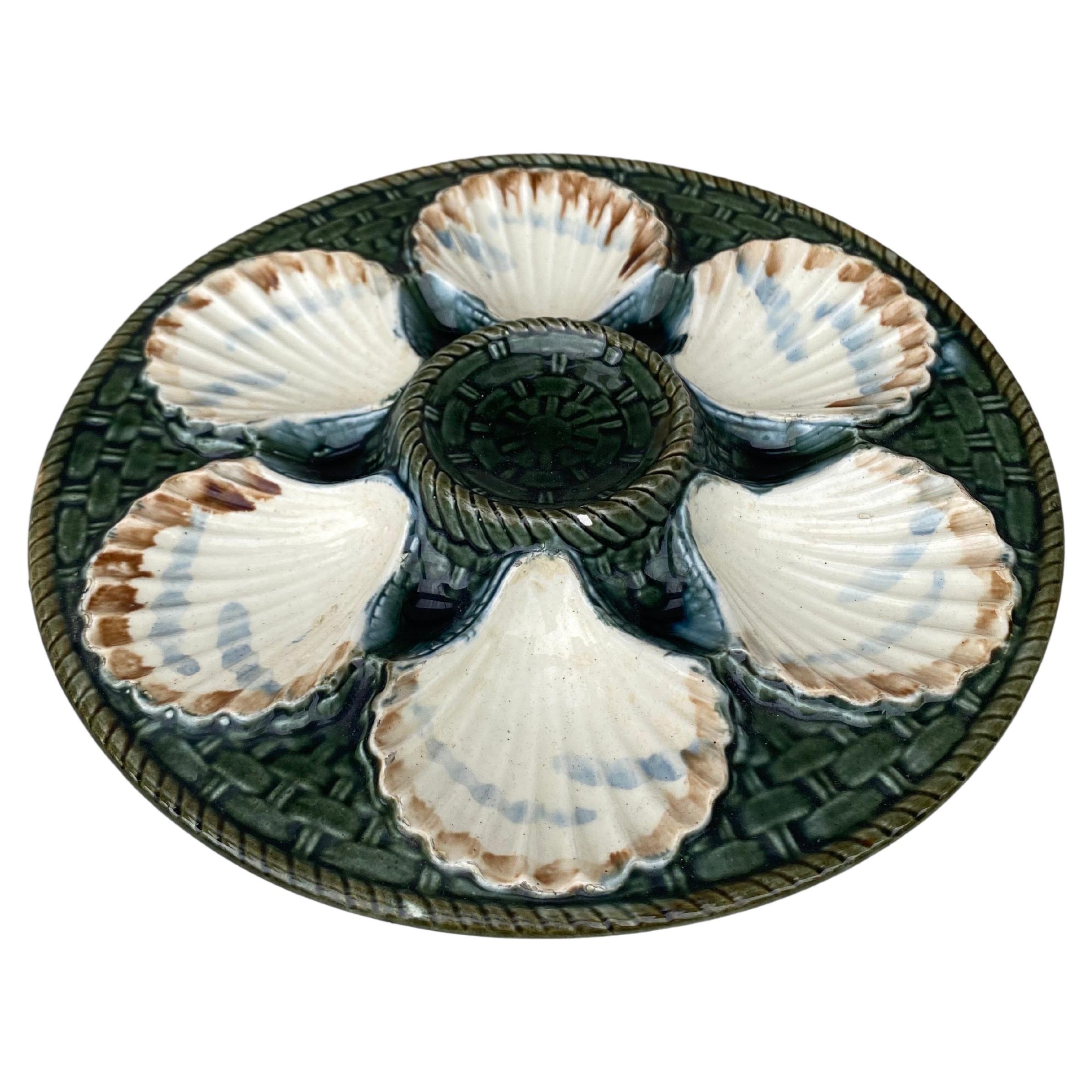 Green Majolica oyster plate, six white wells on a green basket weave, circa 1890 signed Longchamp.