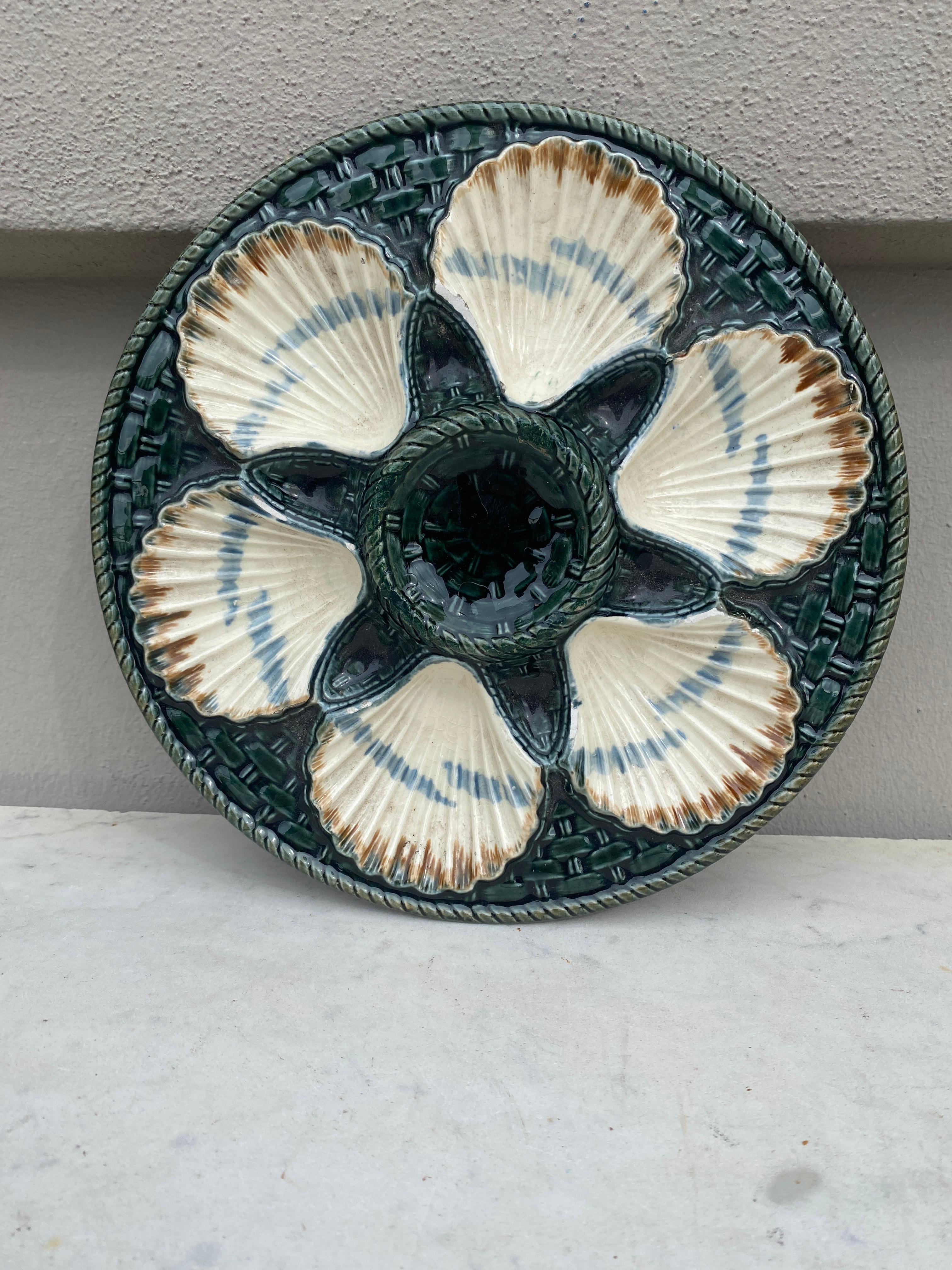 Green Majolica oyster plate, six white wells on a green basket weave, circa 1890 signed Longchamp.
