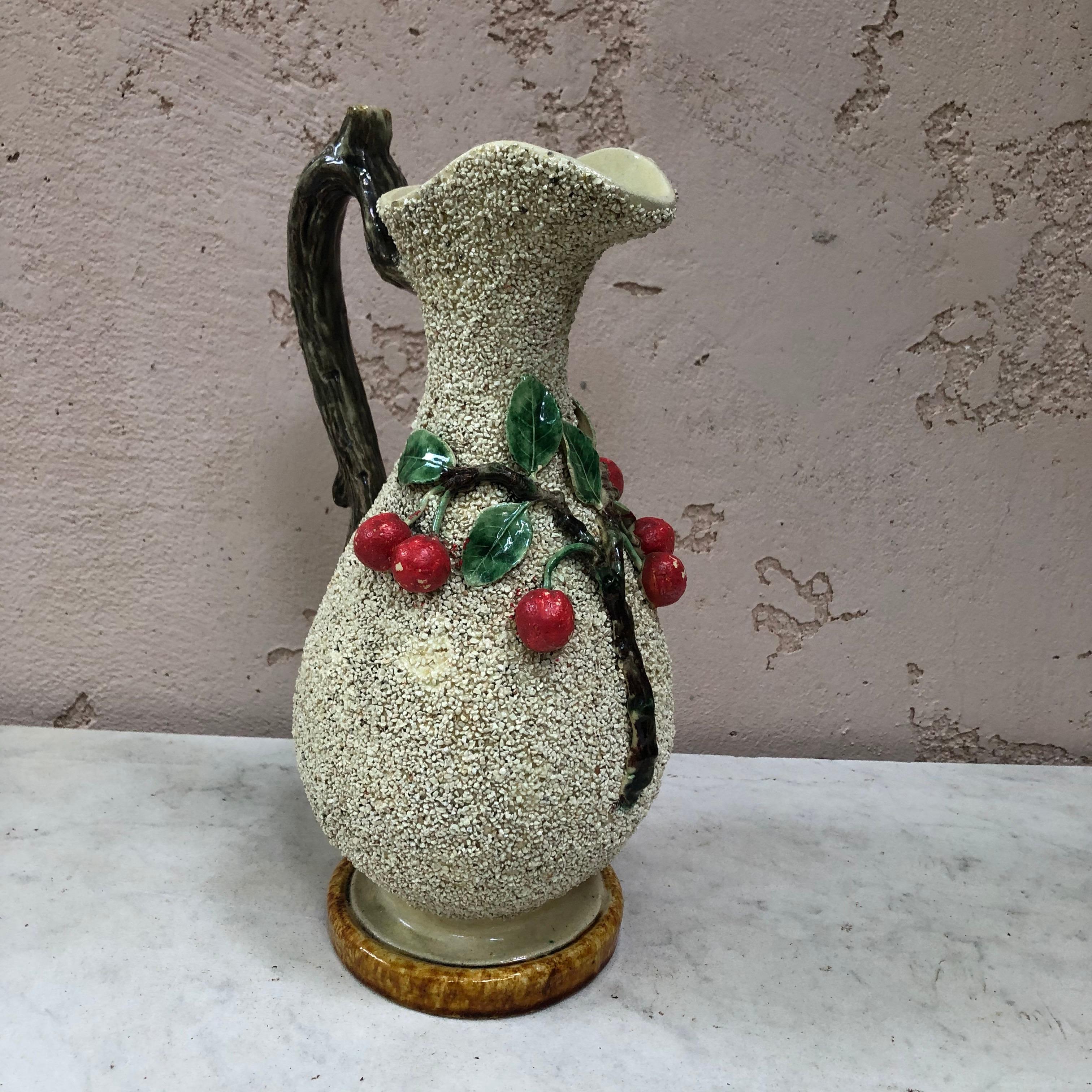 Portuguese majolica pitcher or ewer with cherry motif and branch handle circa 1890 signed Antonio Alves Cunha Caldas da Rainha.