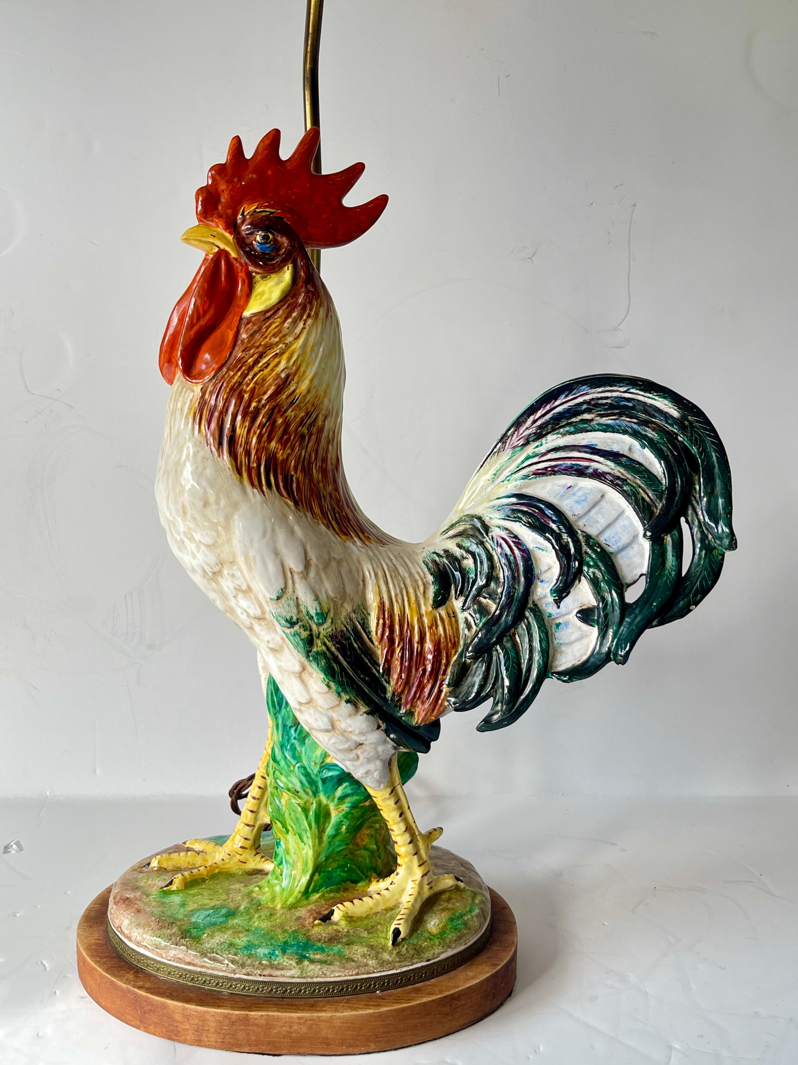 Lampe de table en majolique de la fin du 19ème siècle avec un coq sur un pied en bois avec un cerclage en laiton.
Ce coq est entièrement peint à la main.
Ce coq a probablement été monté sur une lampe dans les années 1950.
La façon dont elle a été