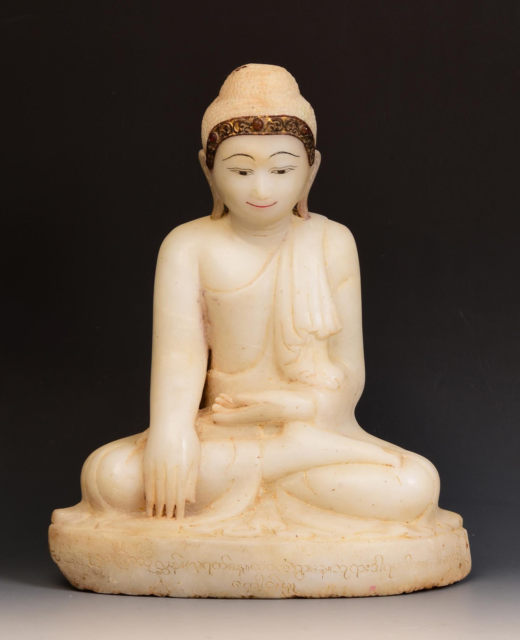 Antique Burmese alabaster Buddha sitting in Mara Vijaya (calling the earth to witness) posture on a base, with inlay of colorful glass pieces on the headband.

Age: Burma, Mandalay Period, 19th Century
Size: Height 41.6 C.M. / Width 33.5 C.M. /
