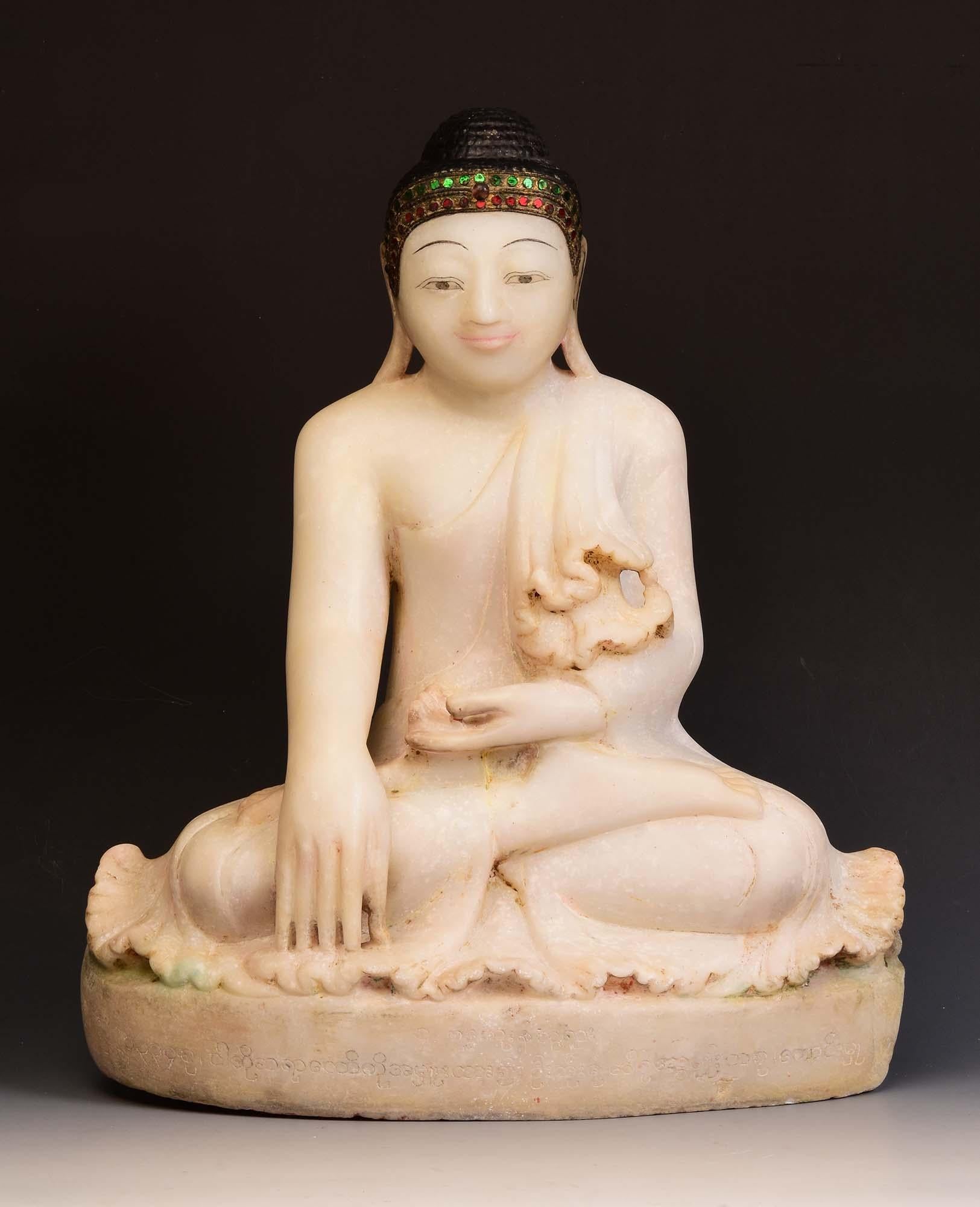 Antique Burmese alabaster Buddha sitting in Mara Vijaya (calling the earth to witness) posture on a base, with inlay of colorful glass pieces on the headband.

Age: Burma, Mandalay Period, 19th Century
Size: Height 51 C.M. / Width 42 C.M. / Depth