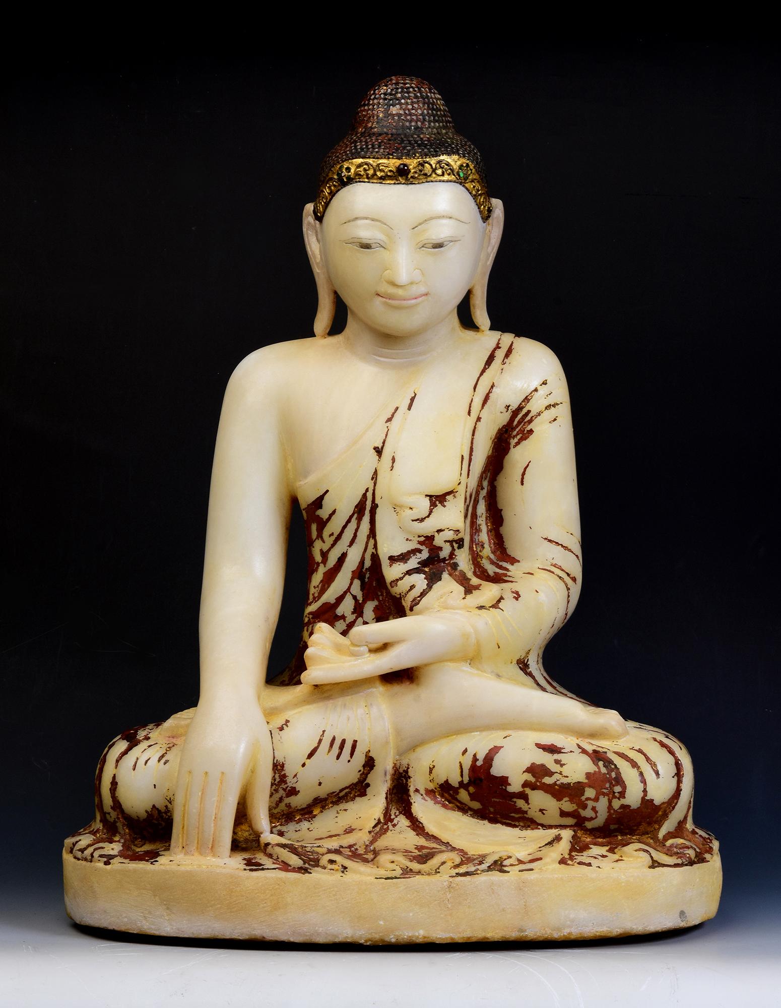 Antique Burmese alabaster Buddha sitting in Mara Vijaya (calling the earth to witness) posture on a base, with original lacquer and inlay of colorful glass pieces on the headband.

Age: Burma, Mandalay Period, 19th Century
Size: Height 55.5 C.M. /