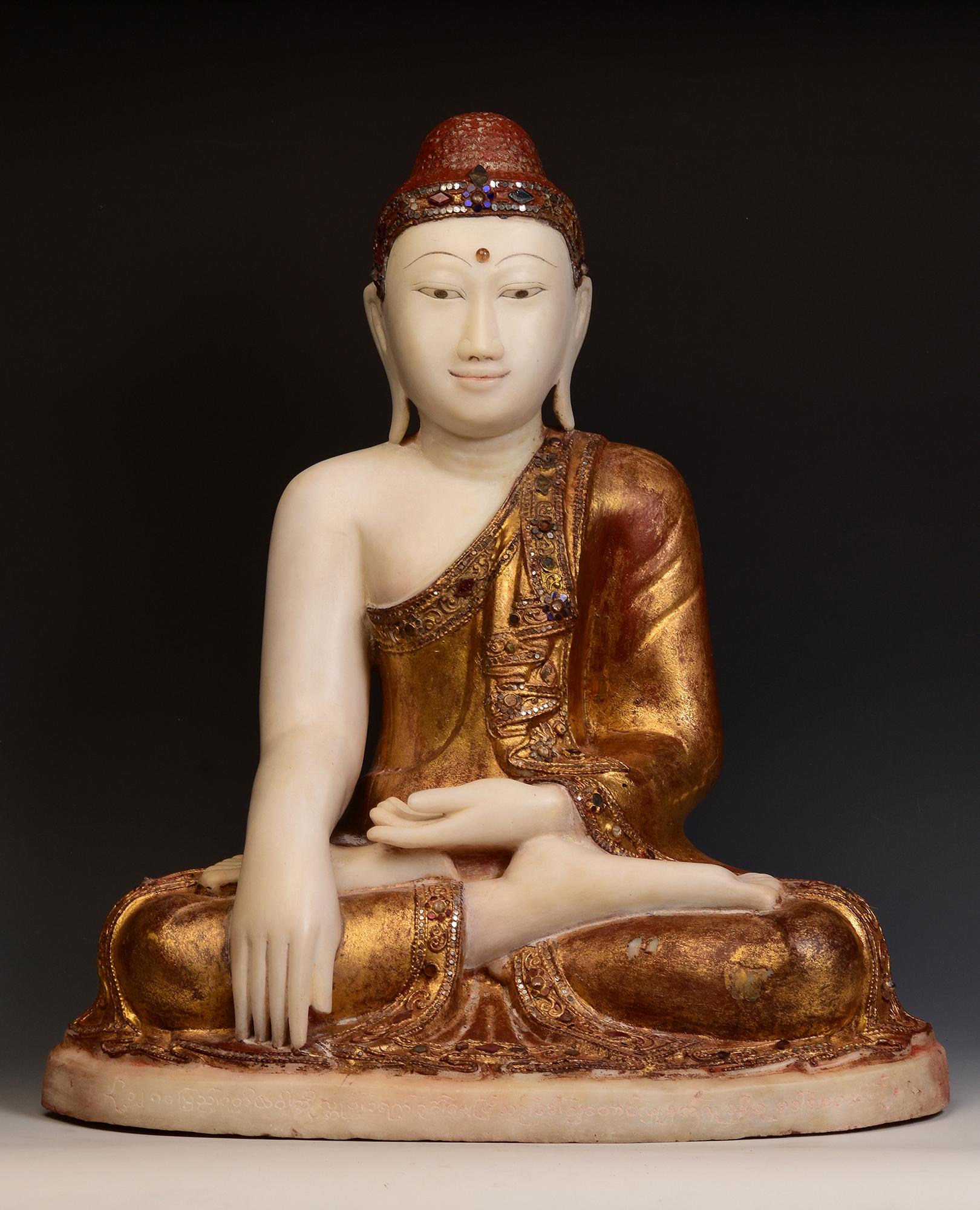 Antique Burmese alabaster Buddha sitting in Mara Vijaya (calling the earth to witness) posture on a base, with original lacquer, gilding and inlay of colorful glass pieces on the headband and borders of the robe. 

Age: Burma, Mandalay Period, 19th