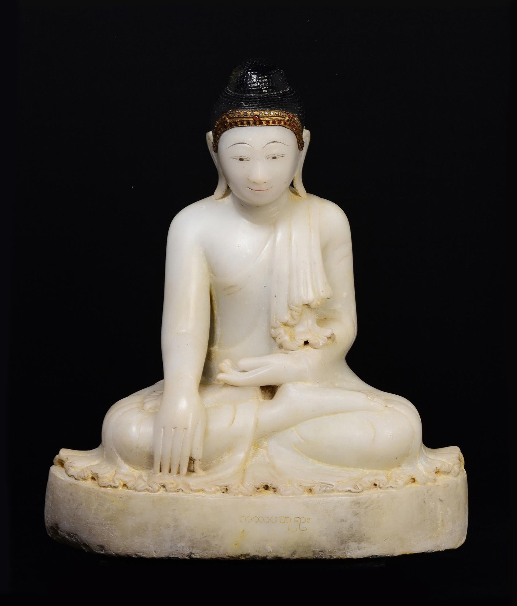 Antique Burmese alabaster Buddha sitting in Mara Vijaya (calling the earth to witness) posture on a base, with inlay of colorful glass pieces on the headband.

Age: Burma, Mandalay Period, 19th Century
Size: Height 54 C.M. / Width 45.5 C.M. / Depth
