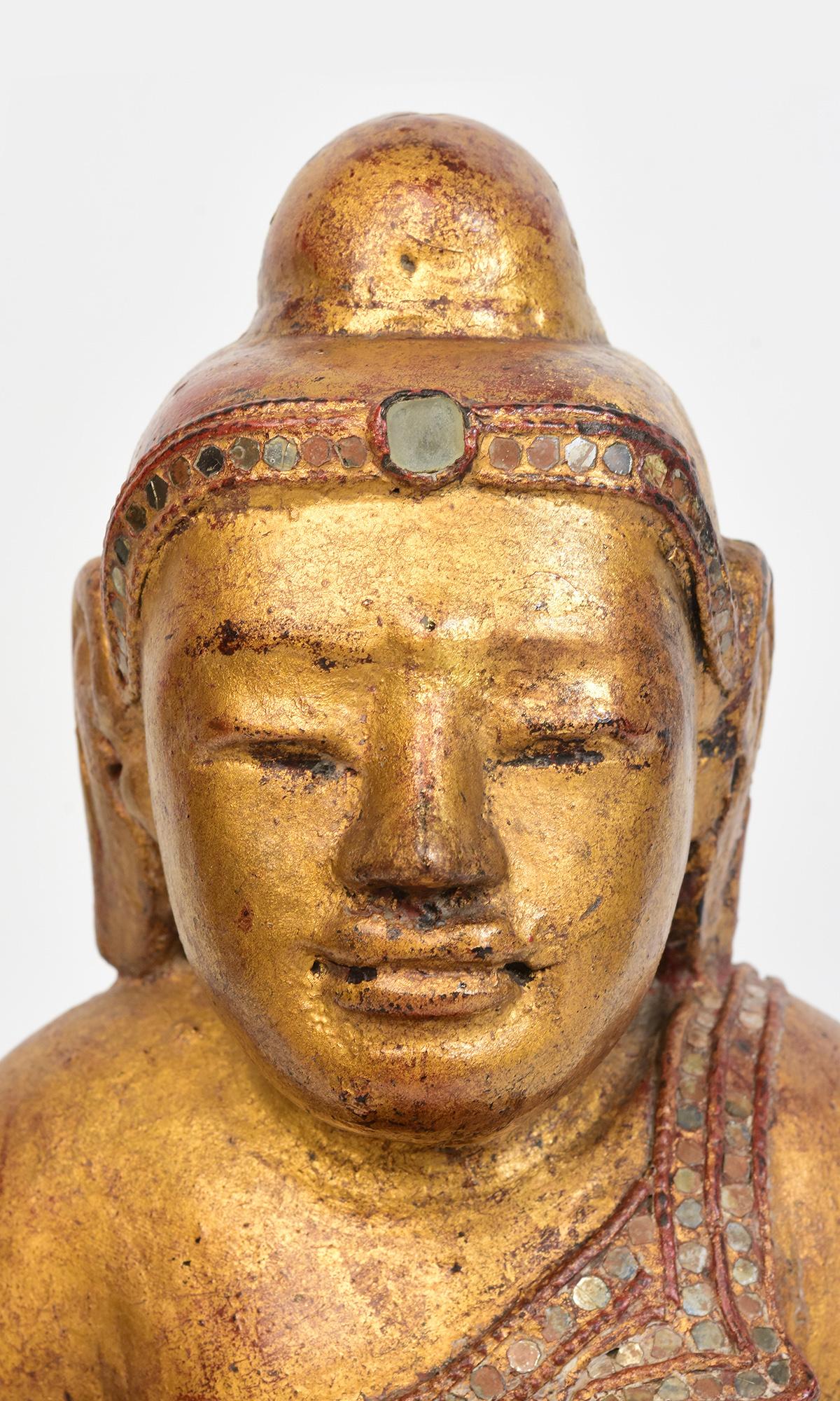 Antique Burmese wooden Buddha sitting in Mara Vijaya (calling the earth to witness) posture on a base with gilded gold and glass.

Age: Burma, Mandalay Period, 19th Century
Size: Height 36 C.M. / Width 31 C.M. / Depth 24 C.M.
Condition: Nice