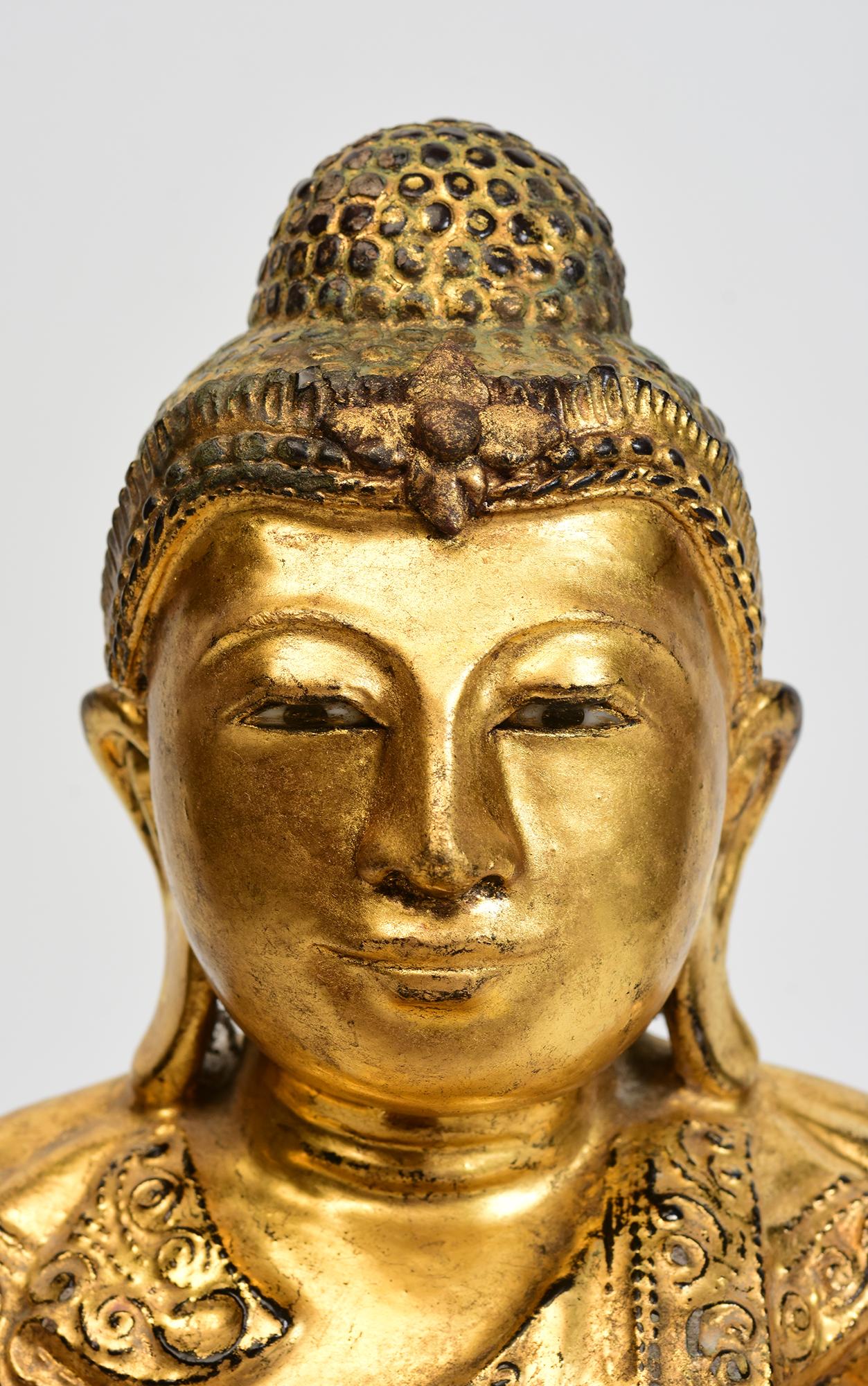 Antique Burmese wooden Buddha sitting in Mara Vijaya (calling the earth to witness) posture on a base with gilded gold. 

Age: Burma, Mandalay Period, 19th Century
Size: Height 33.3 C.M. / Width 31 C.M. / Depth 22.5 C.M.
Condition: Nice condition