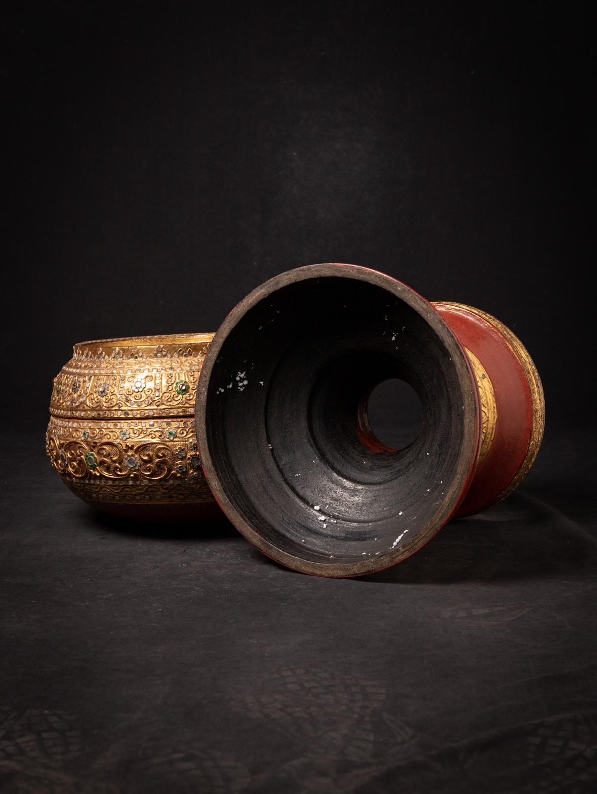 The antique Burmese offering vessel is a stunning piece of craftsmanship, skillfully made from lacquerware. Standing at a height of 55 cm and with a diameter of 37 cm, it boasts an impressive presence. Gilded with 24-karat gold in the Mandalay