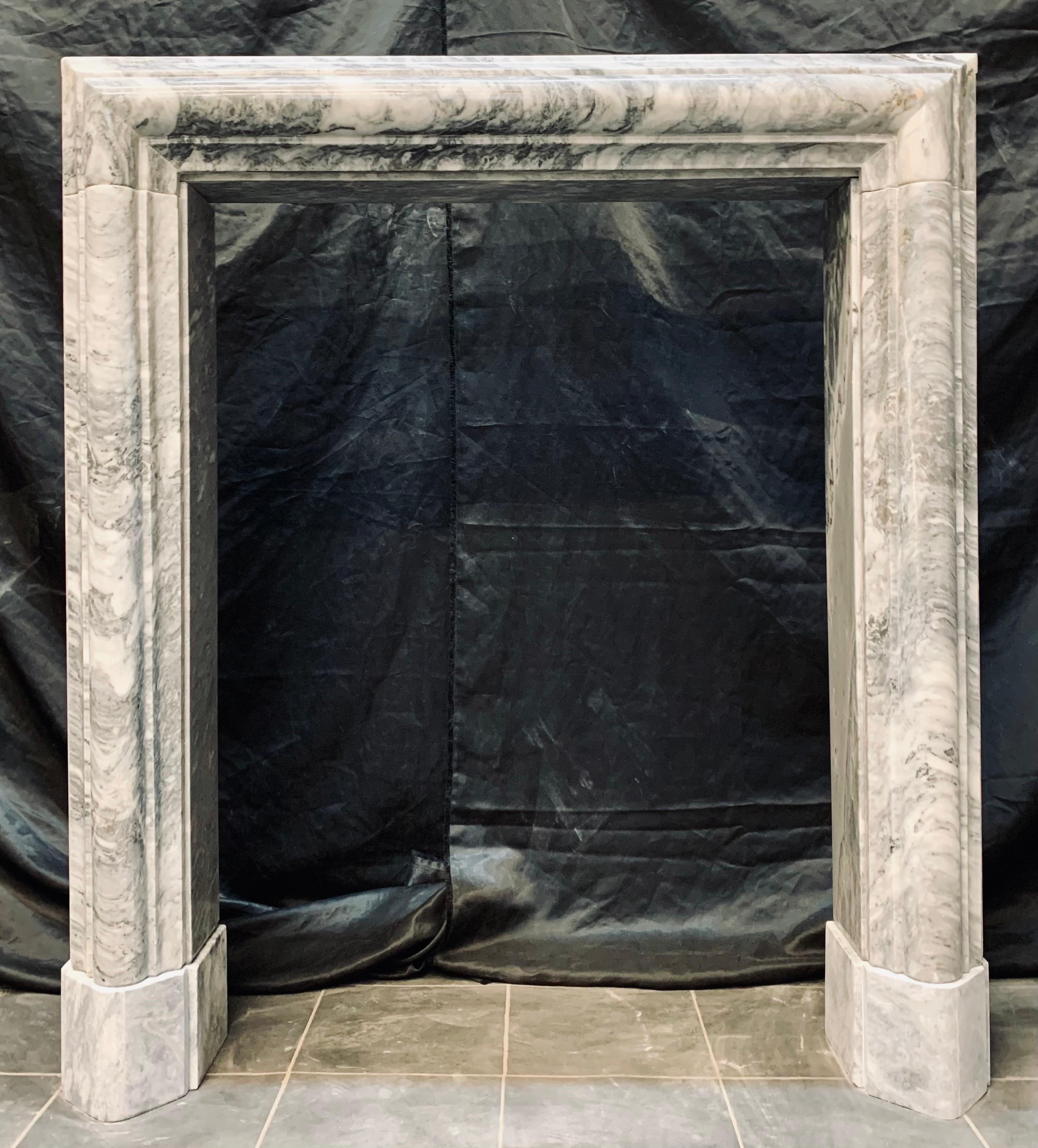 A tall 19th century manner solid Bardigilo bolection marble fireplace surround. A well carved bolection shaped frieze section rests above a set of matching bolection jambs, and a generous return section gives this wonderful piece depth, all