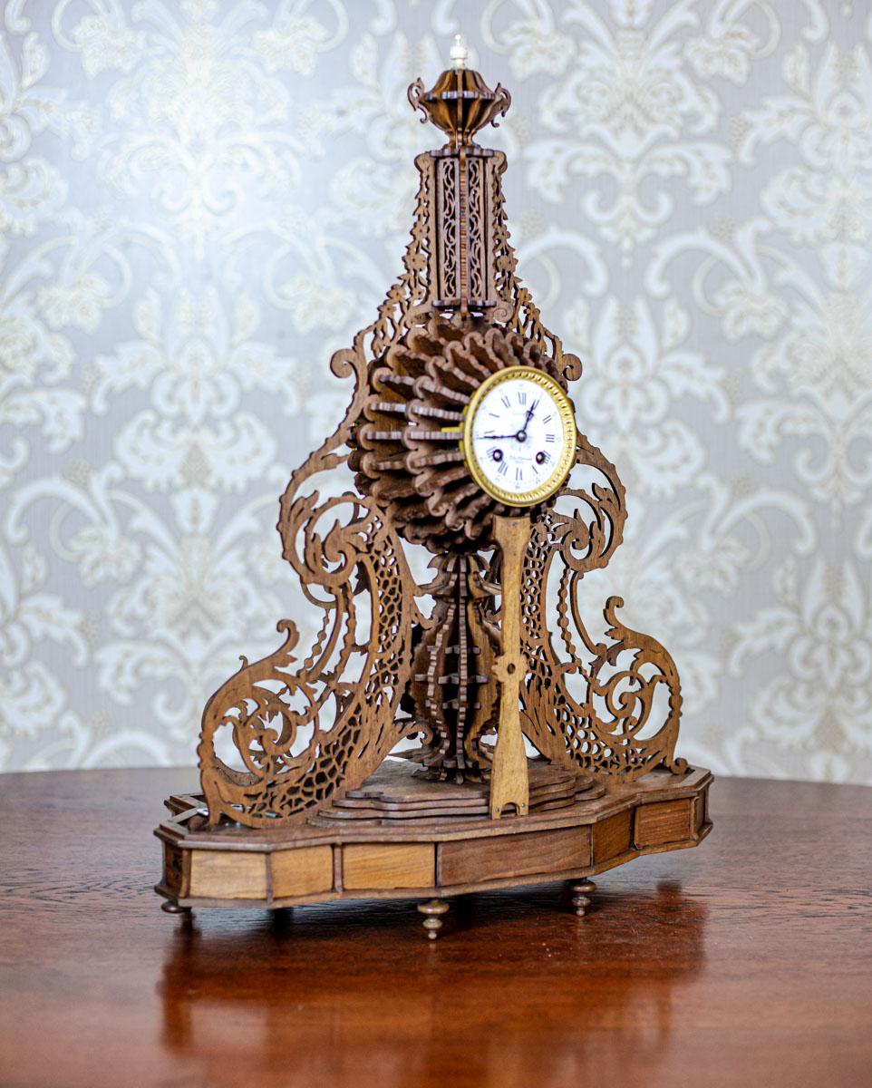 Elaborately Carved Exotic Wood Mantel Clock from the Late 19th Century

We present you this unique mantel clock in an openwork, elaborately carved wooden case, which is made of exotic wood.
The whole item is integrated with a wooden base on brass