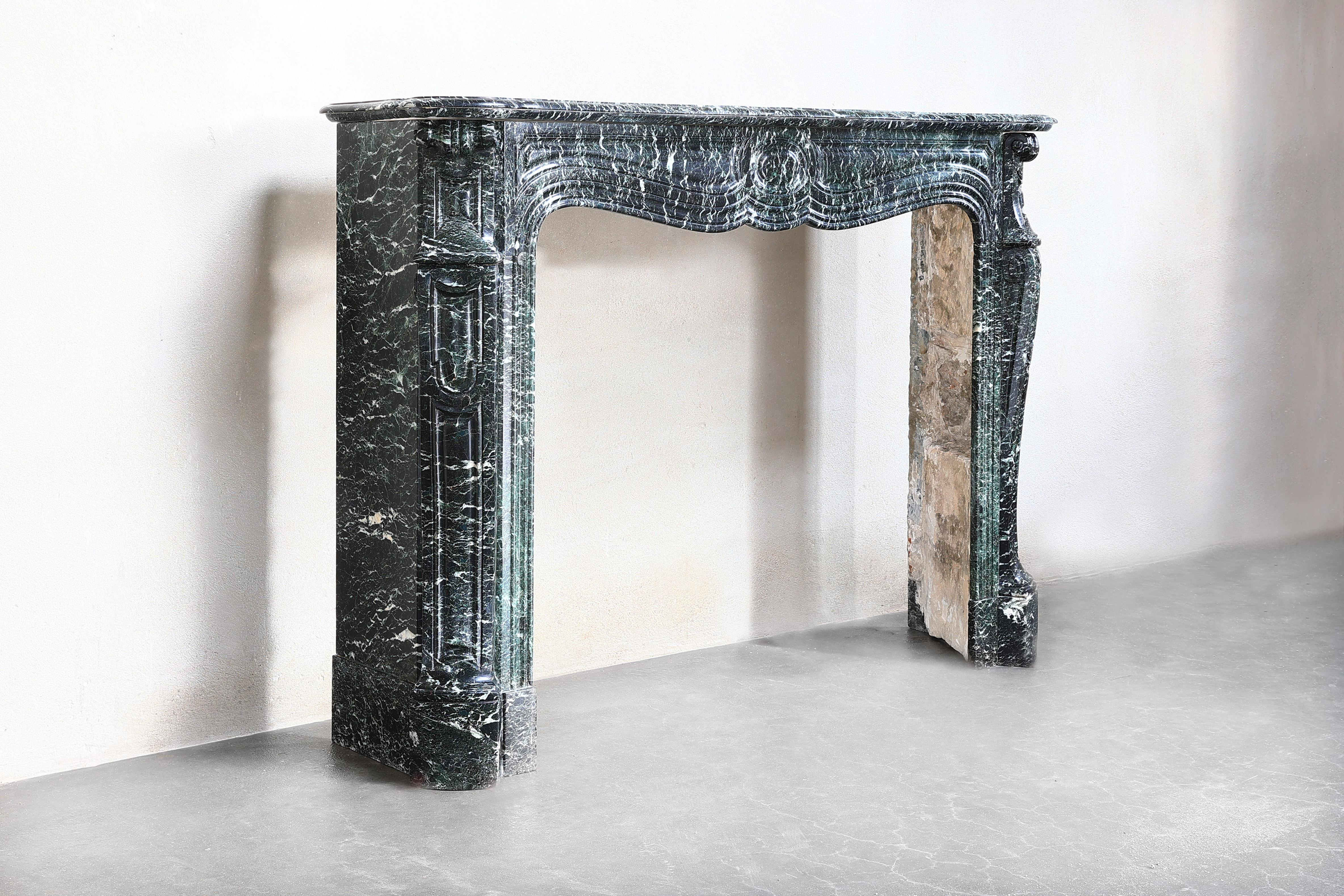 Beautiful antique fireplace made of Vert de Mer marble in the style of Pompadour from 1850-1870. Pompadour fireplaces are recognizable by the rounding in the middle. This is a very charming and stylish mantle made of a special marble type.