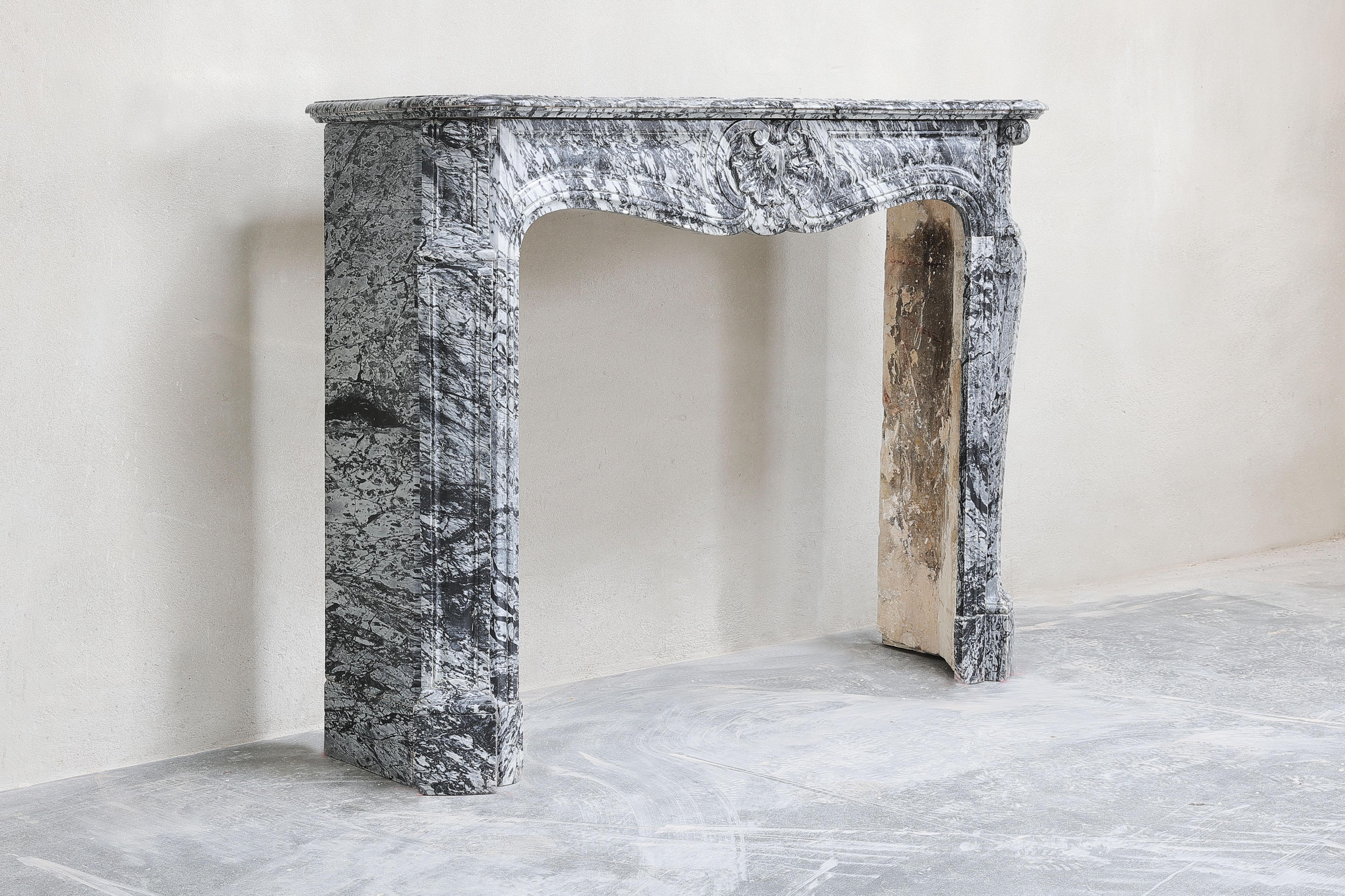 Beautiful antique fireplace made of Blue Fleuri marble! This fireplace is in Louis XV style and has a scallop in the middle. The fireplace dates from the 19th century and is in good condition.
