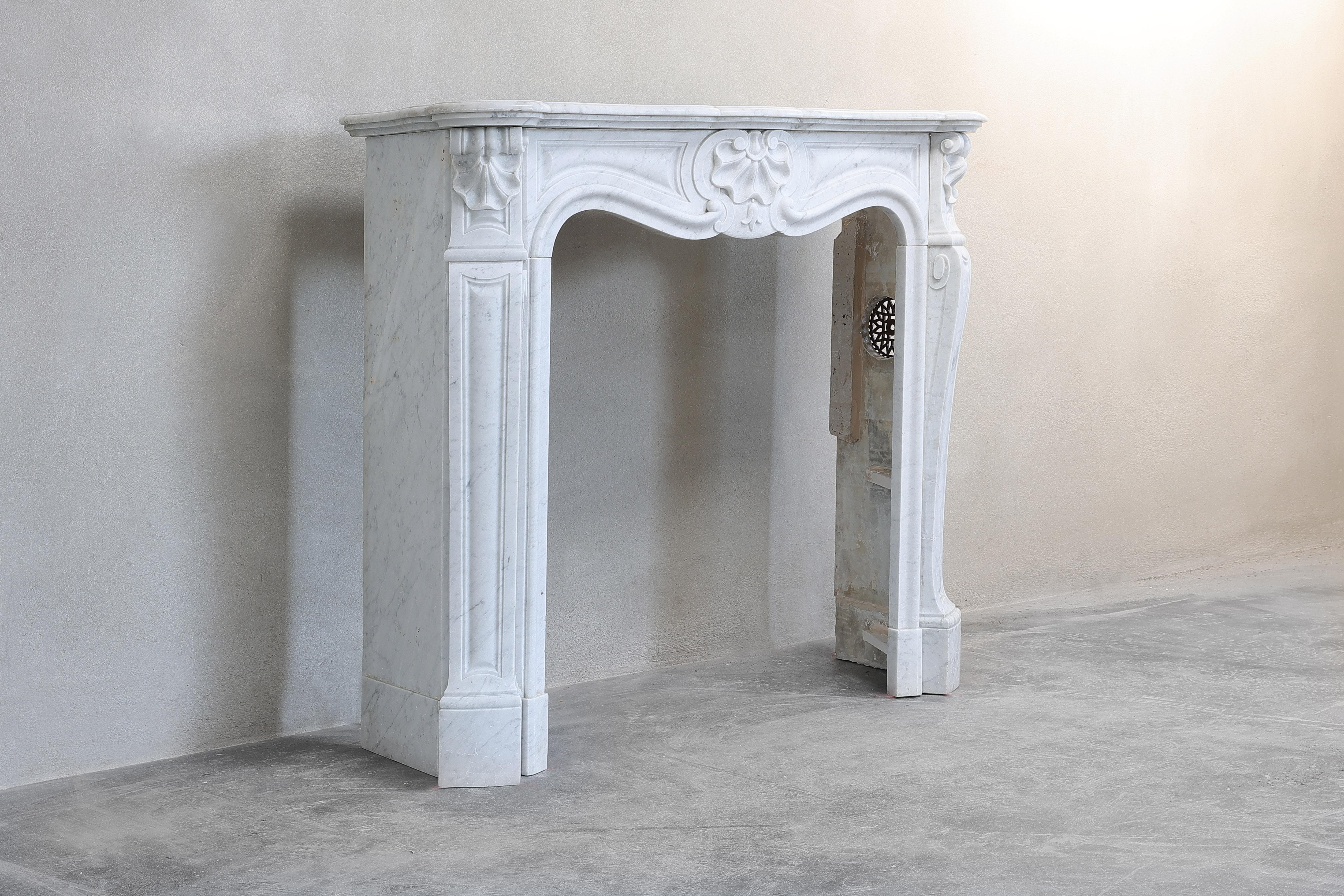 Beautiful compact fireplace made of Carrara marble from Italy! This white marble is extracted from the quarries in Carrara, Italy. A beautiful marble type that exudes a lot of charm. This fireplace originates from the Louis XV and is equipped with