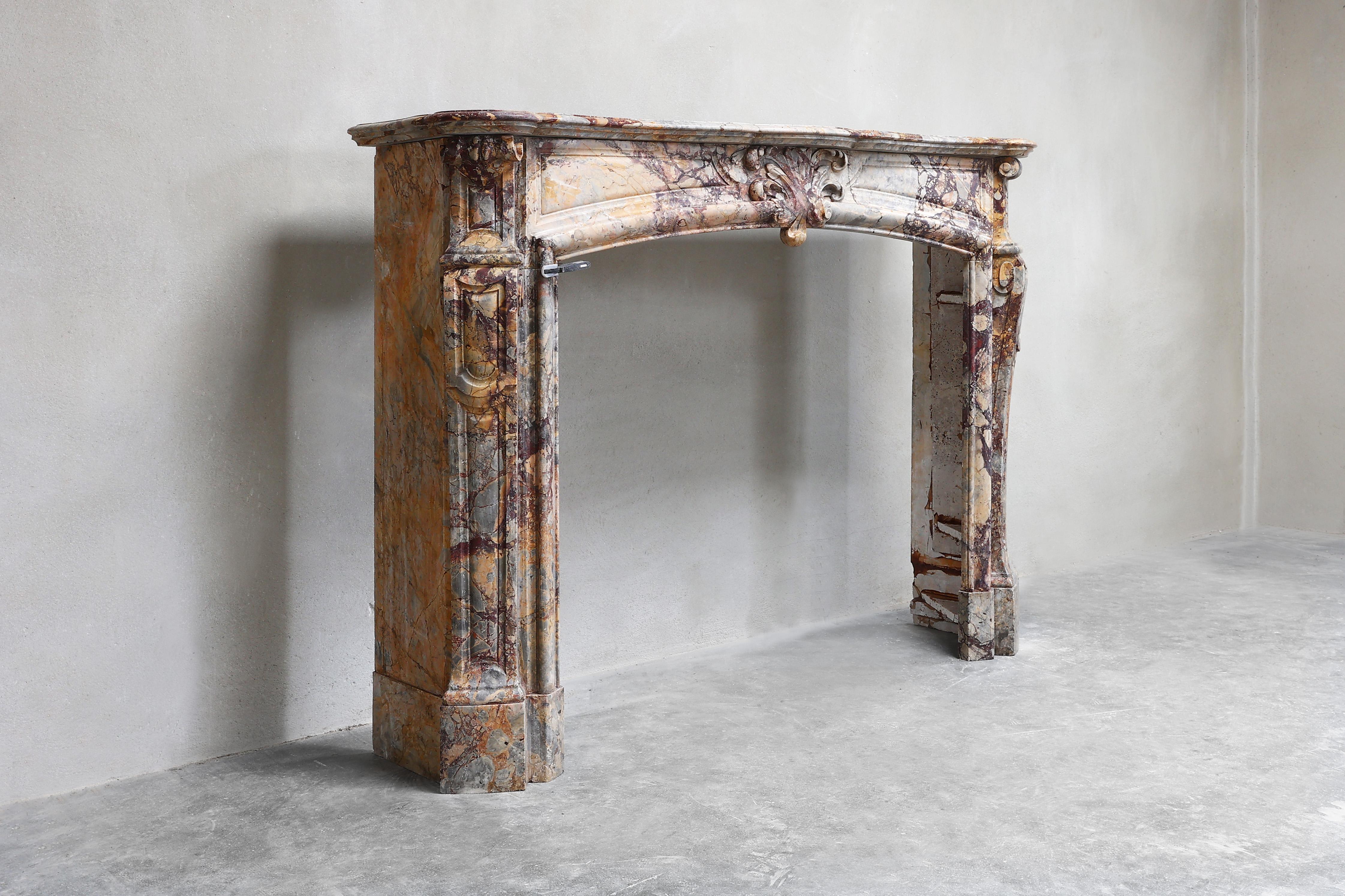 Beautiful antique fireplace made of Breche de Medou marble in the style of Regence Pompadour. A fireplace made of a special colorful marble from France! This fireplace dates from 1870-1880. A beautiful piece of furniture for any interior!
