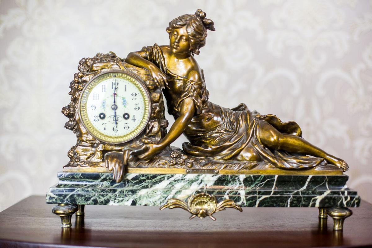 We present you this mantel set composed of a clock with figures and two candlesticks in the shape of vases.
The casts are made of bronzed zamak on a marble base.
The arrangement is titled La Soure (eng. Source), signed by F. Moreau.
The whole is