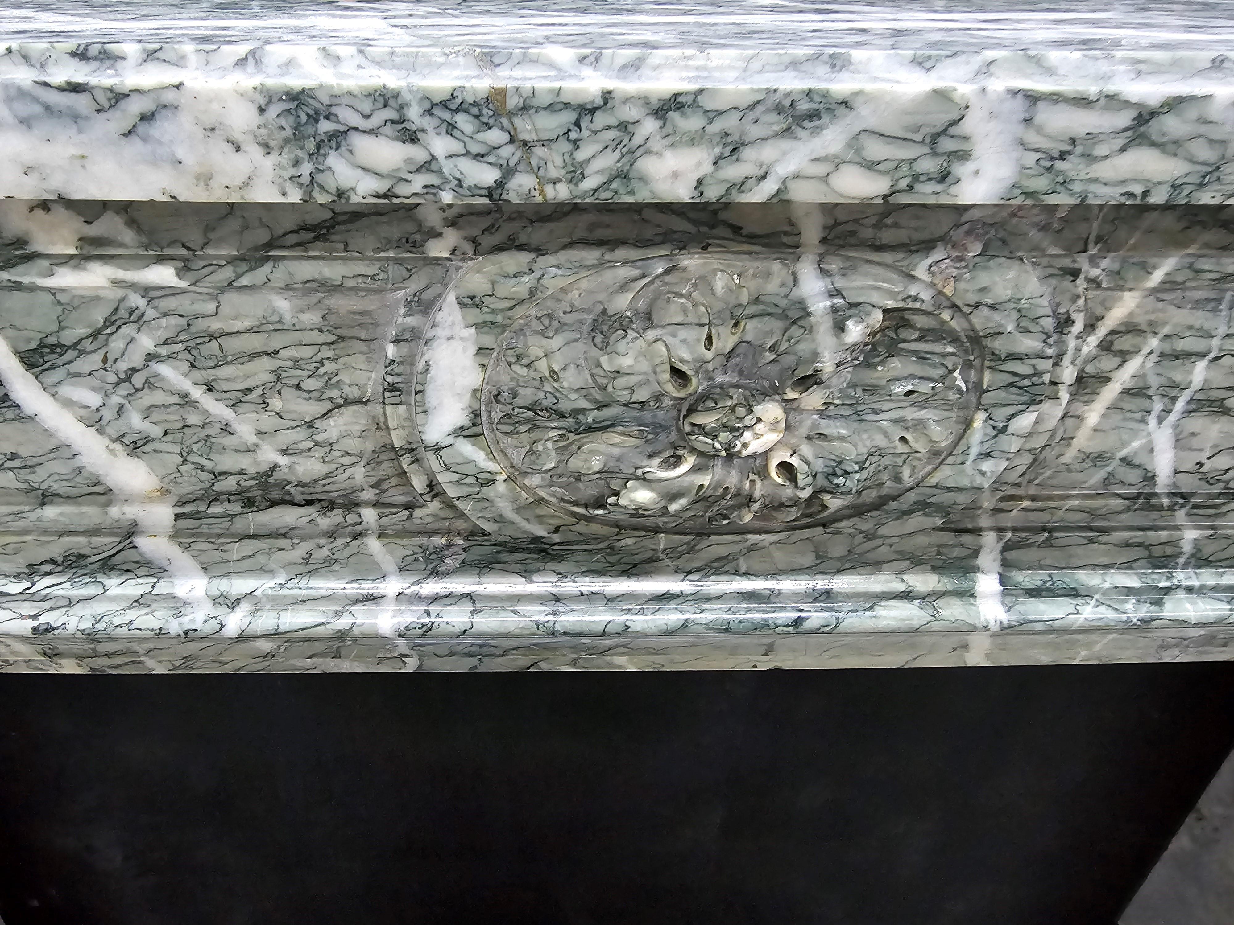Kaminsims aus dem 19. Jh. im Stil eines Louis XVI mit Bogenfront aus grünem Campan-Marmor mit geschnitzter zentraler Kartusche und Eckblöcken.
Öffnung: 40 
